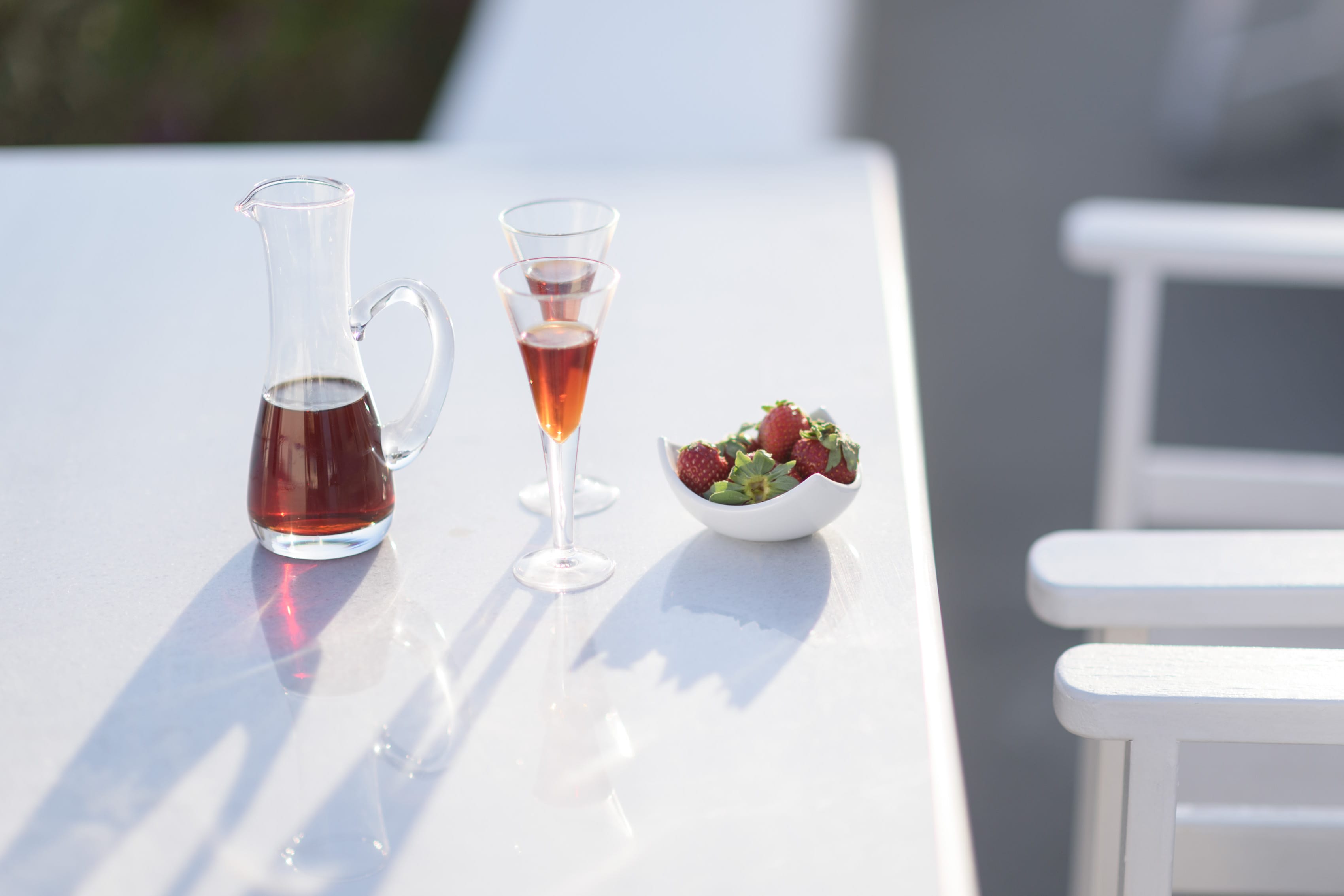 a glass of wine and a bowl of fruit on a table
