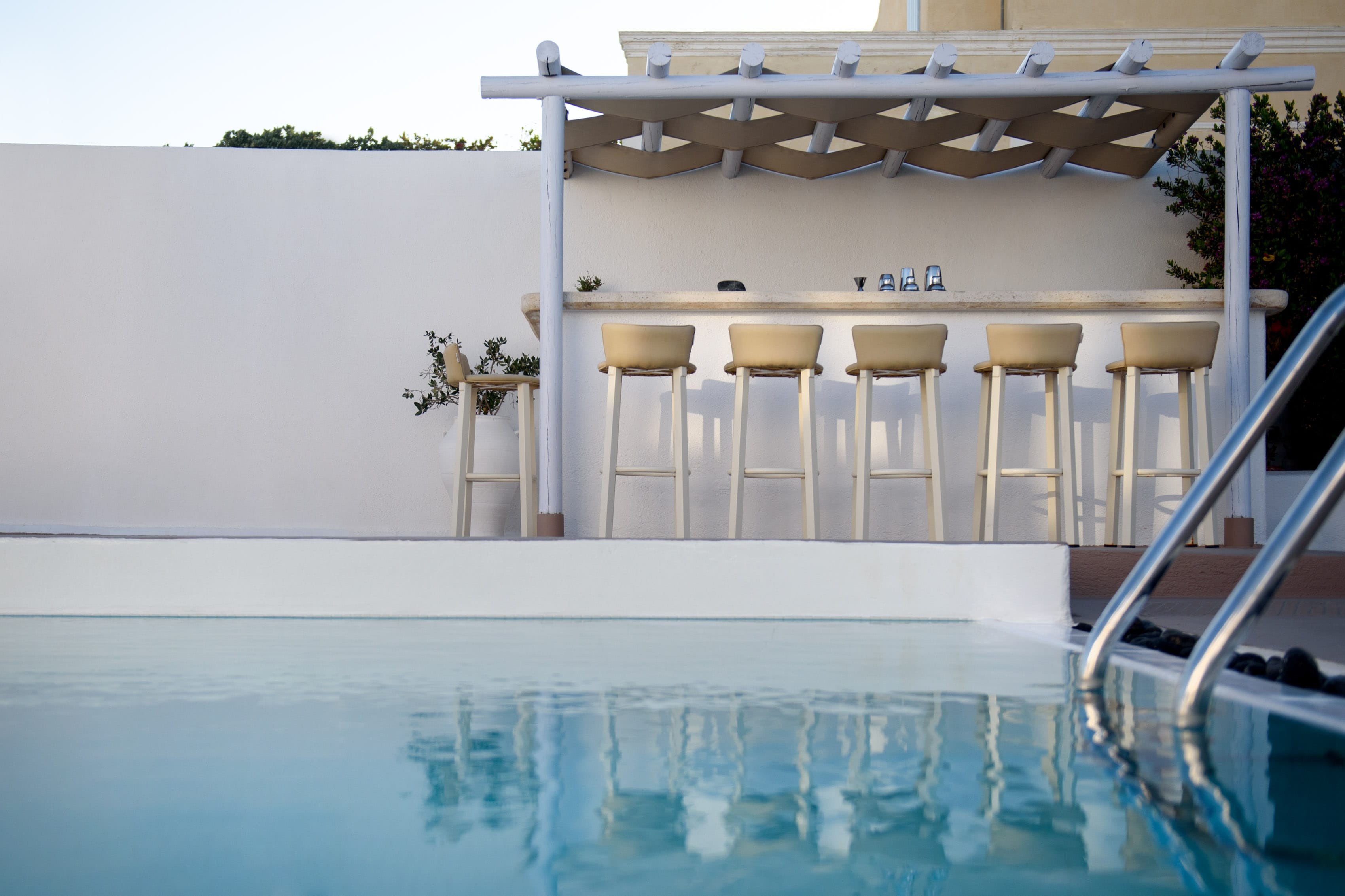 a pool with stools and a bar