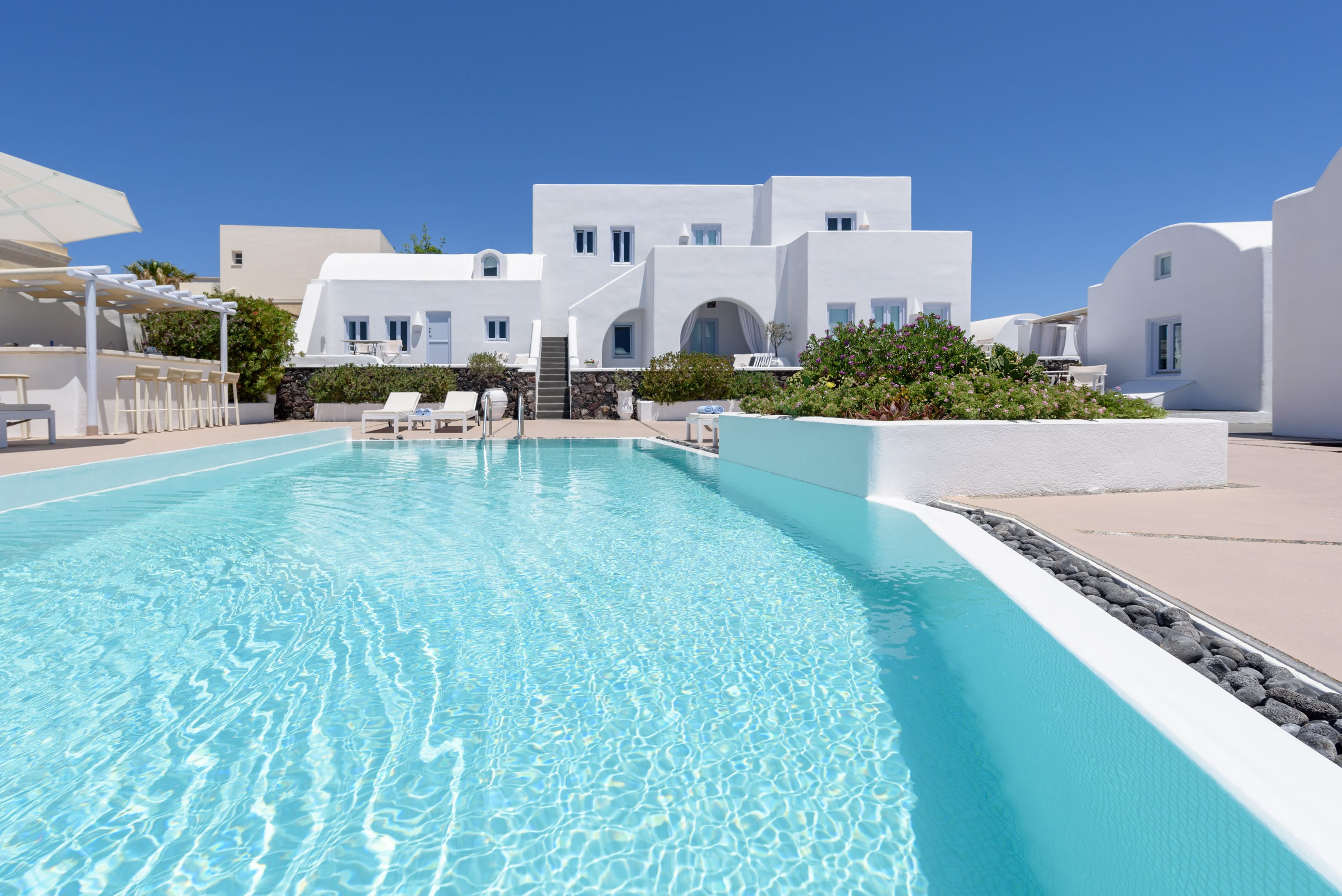 a swimming pool with a white building in the background