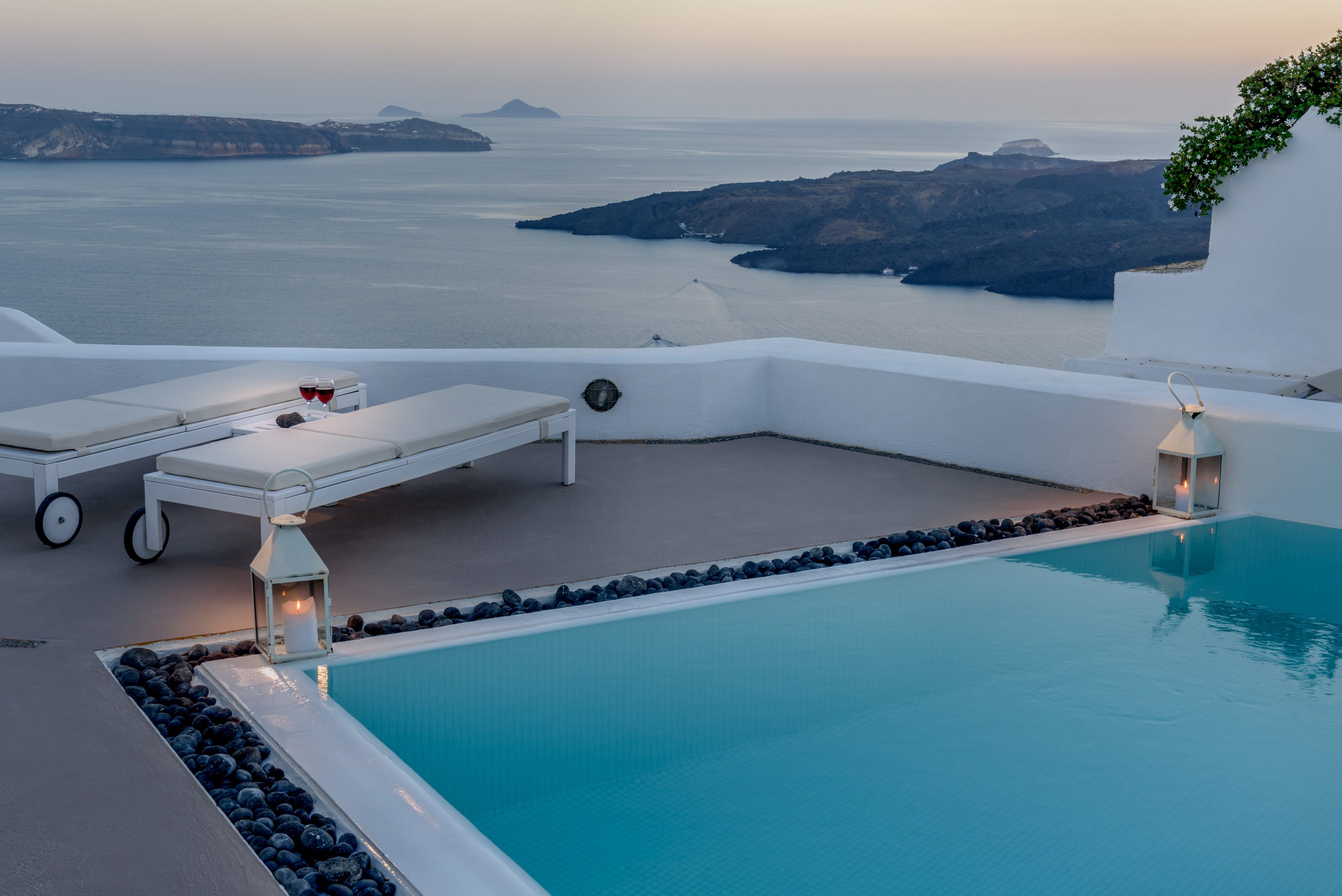 a pool with a table and chairs overlooking the ocean