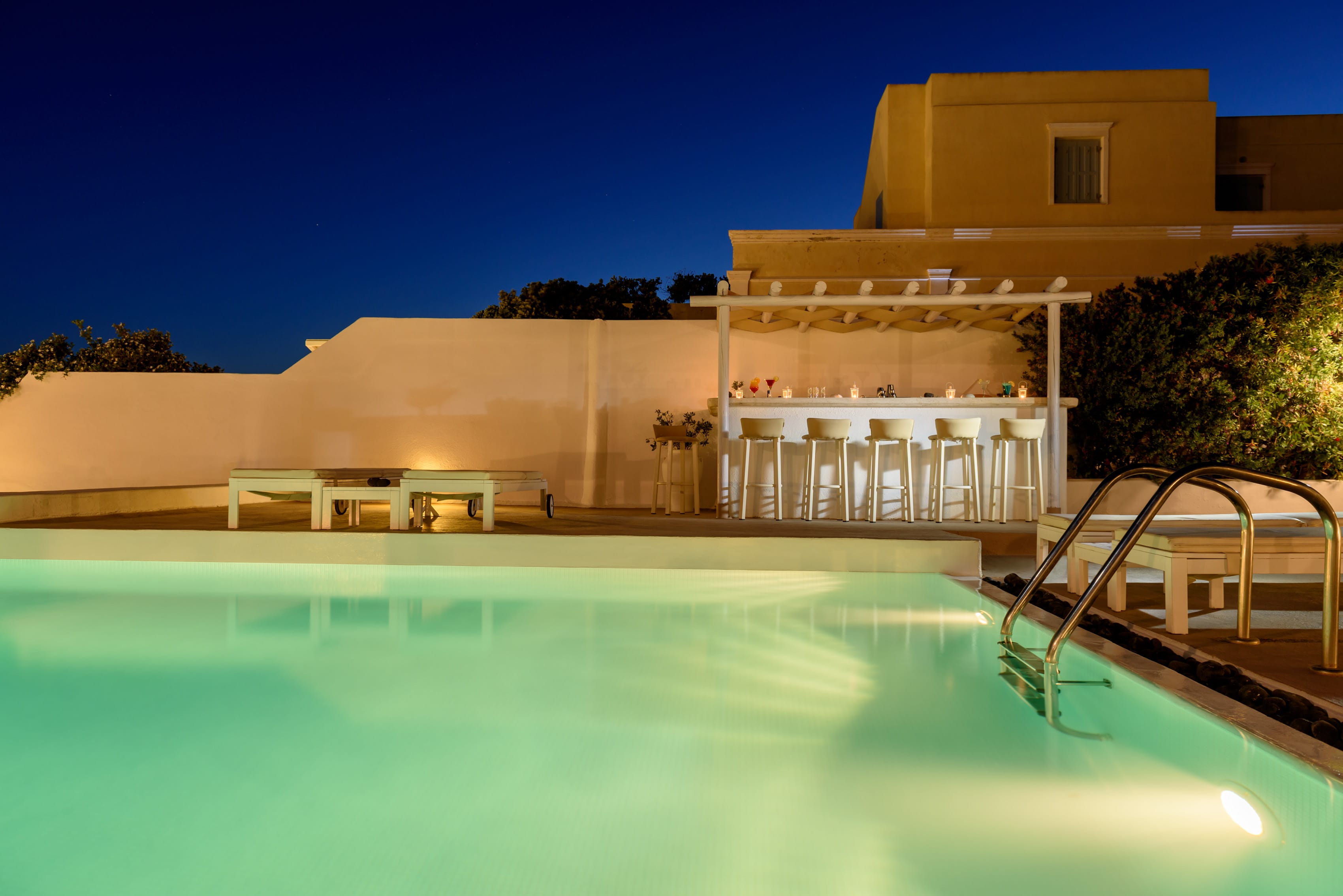 a pool with a bar and chairs