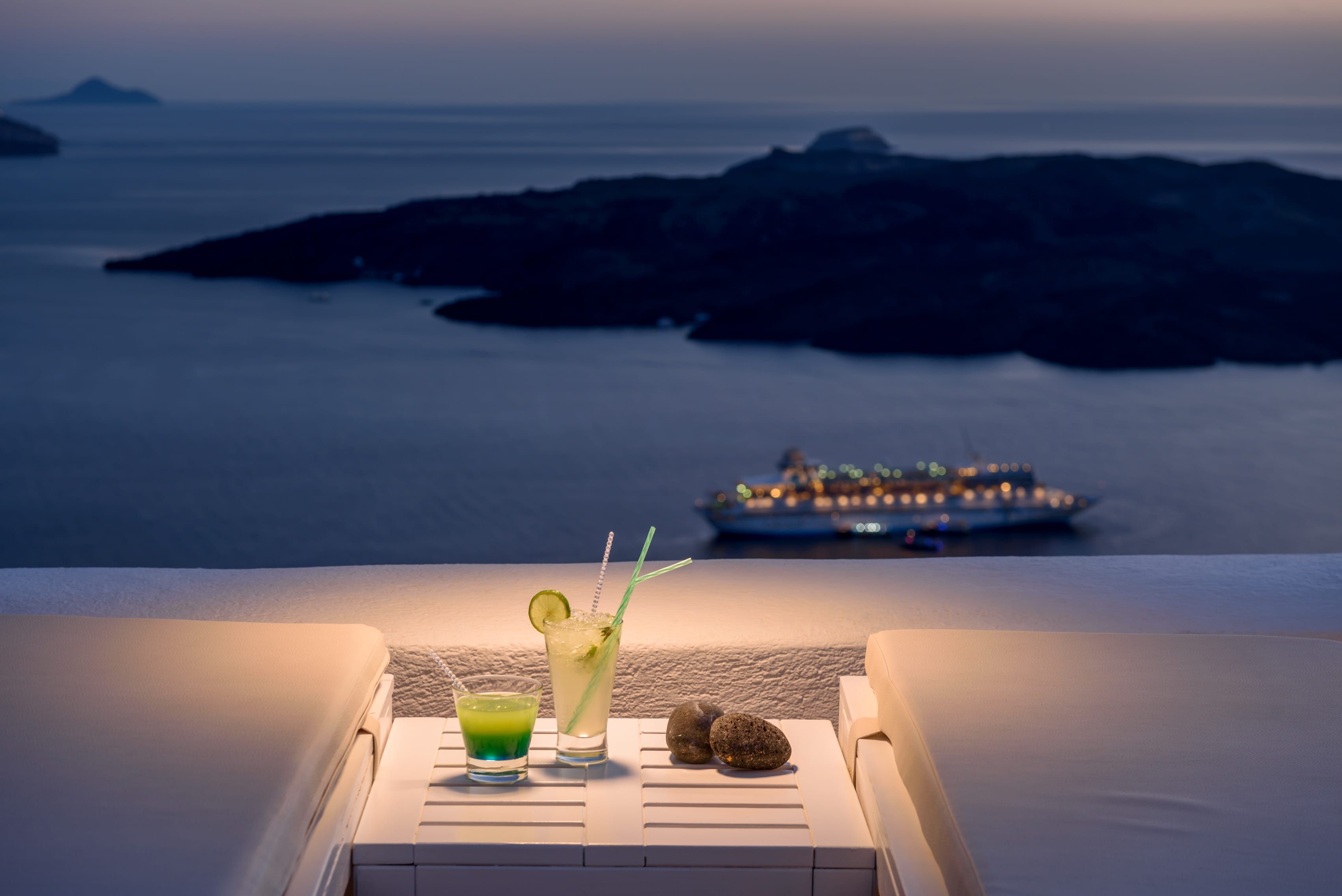 a table with drinks on it and a boat in the background
