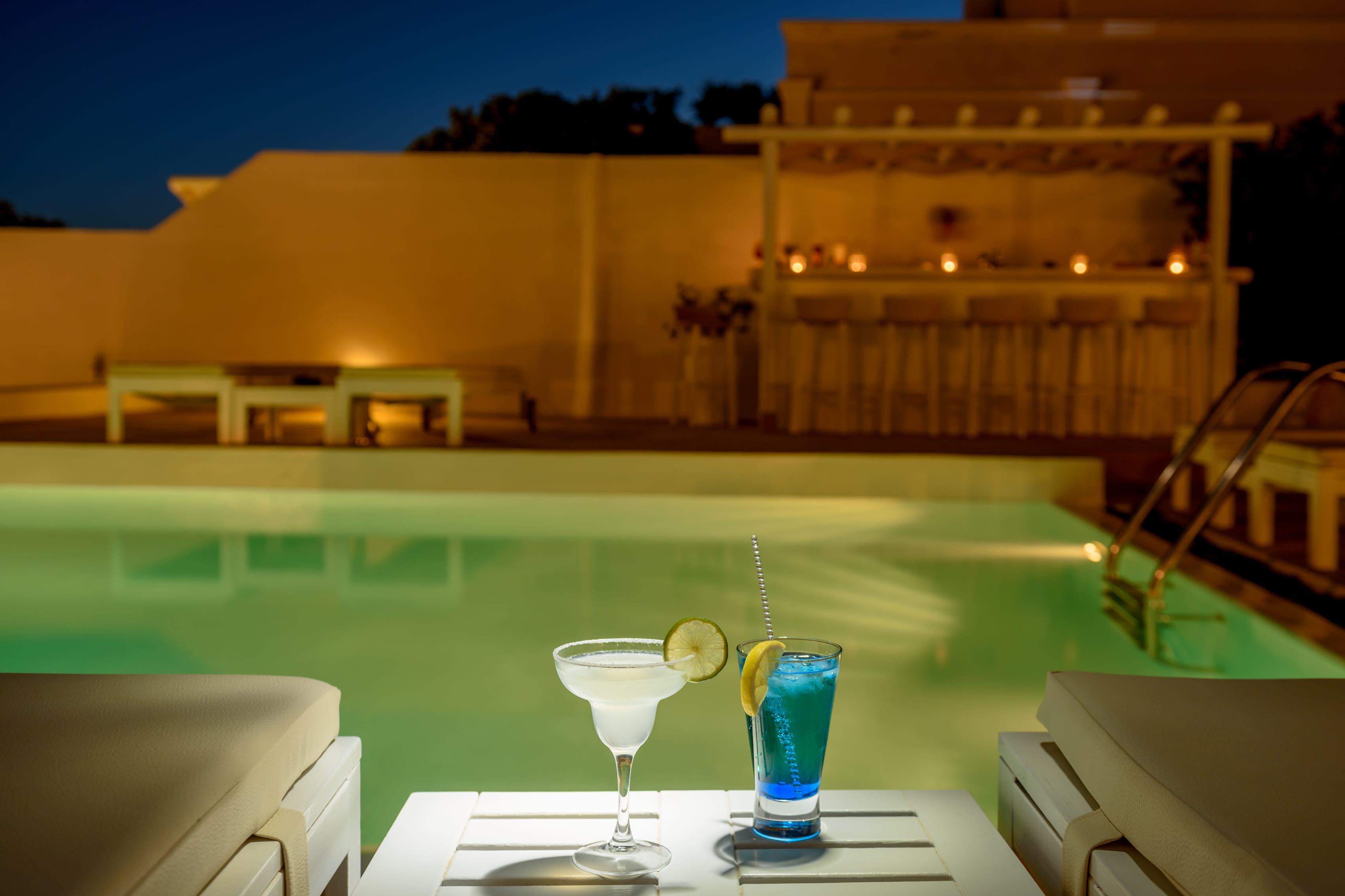 a cocktails on a table by a pool