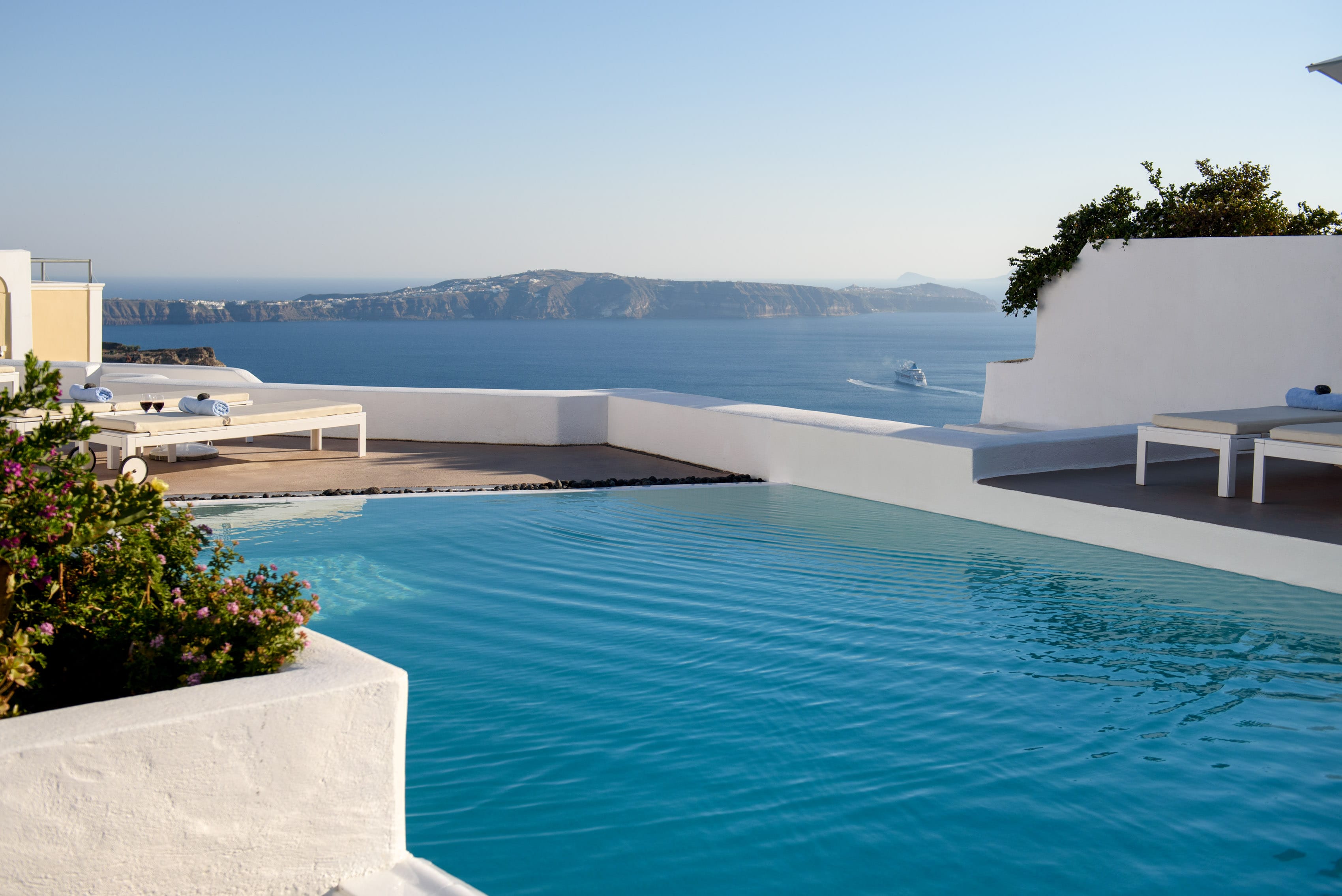 a swimming pool with a deck chair and a white wall