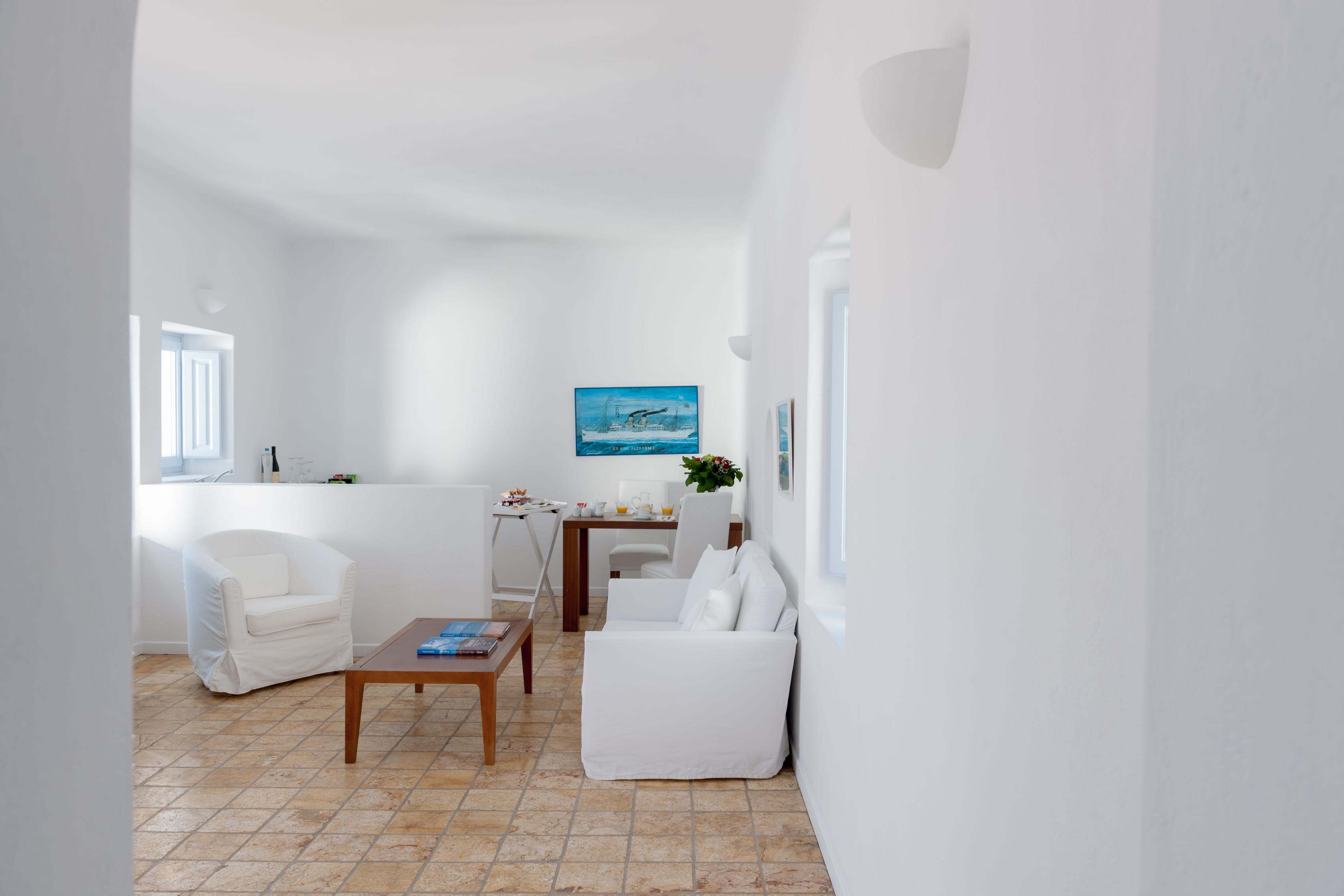 a room with white furniture and a table