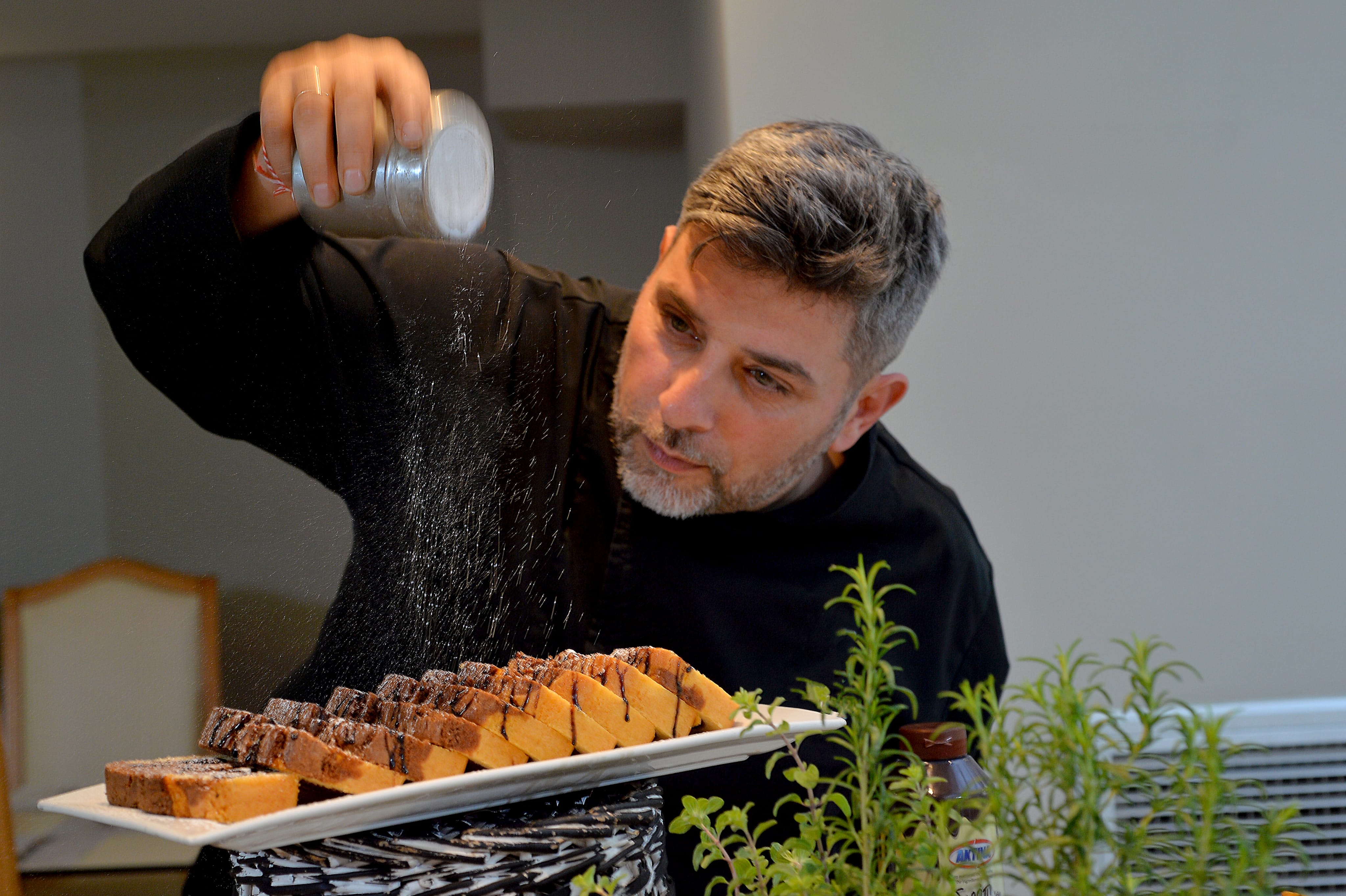 a person pouring salt into a plate of food