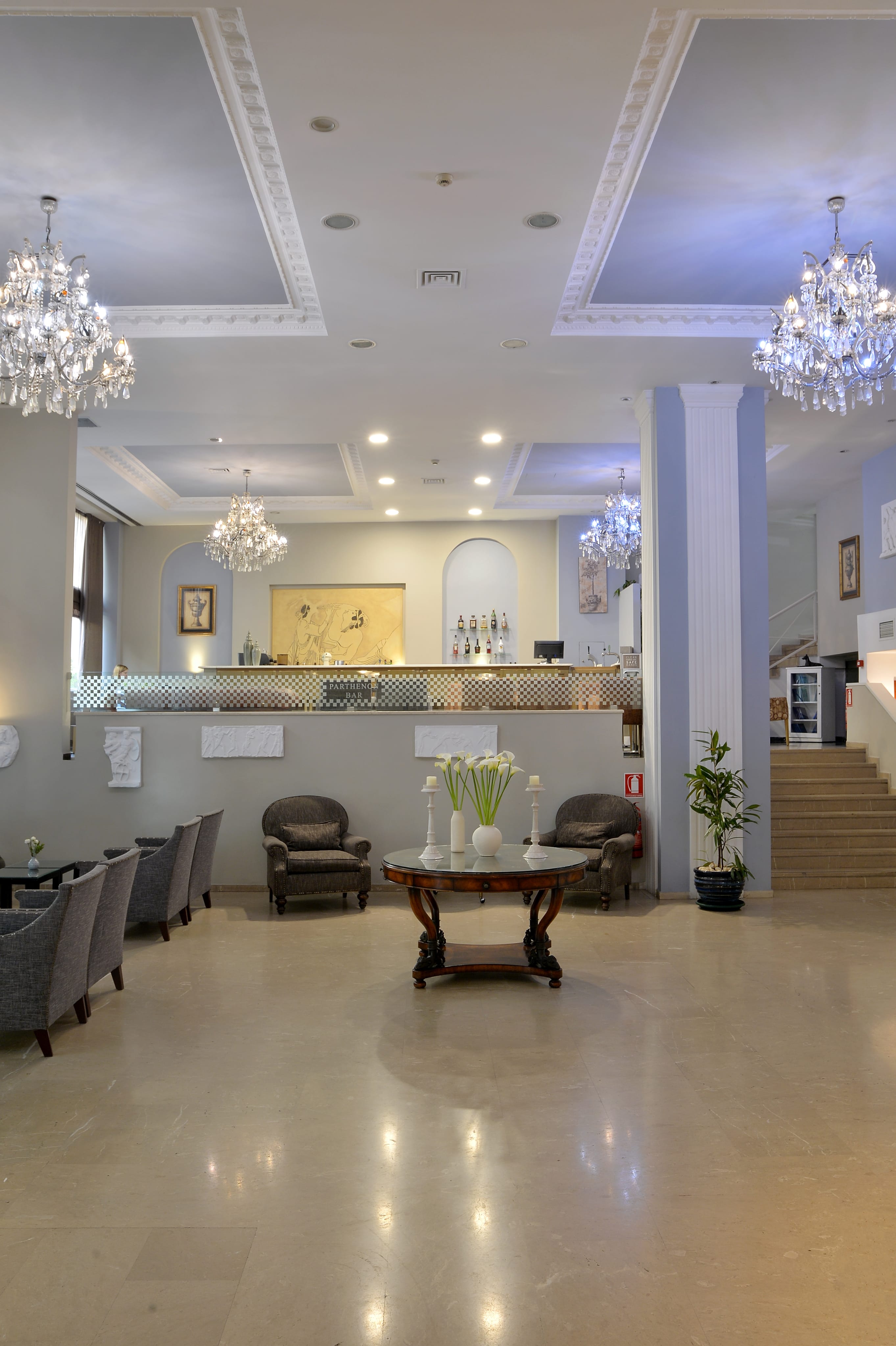 a lobby with chandeliers and a table