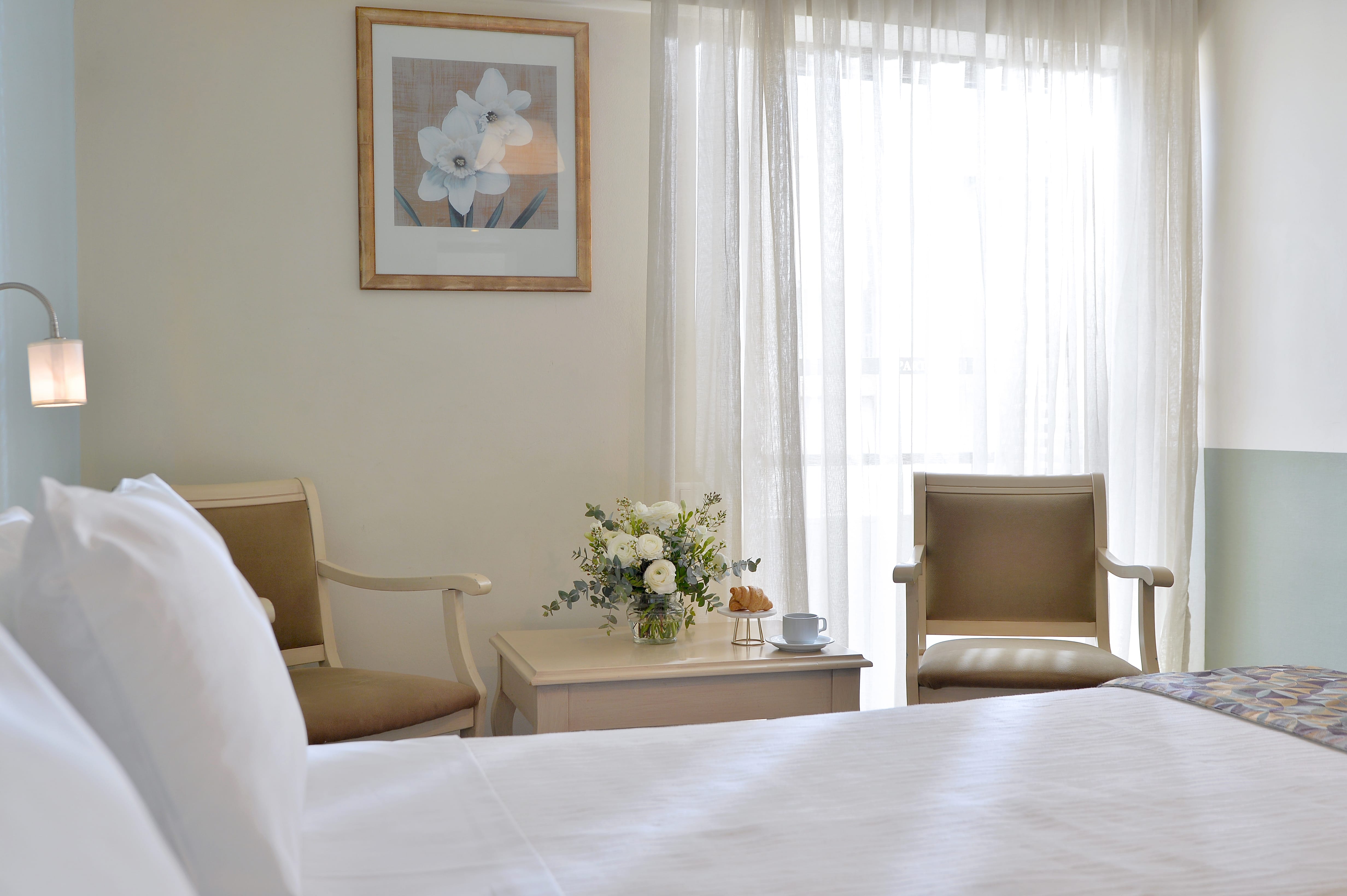a room with a bed and chairs