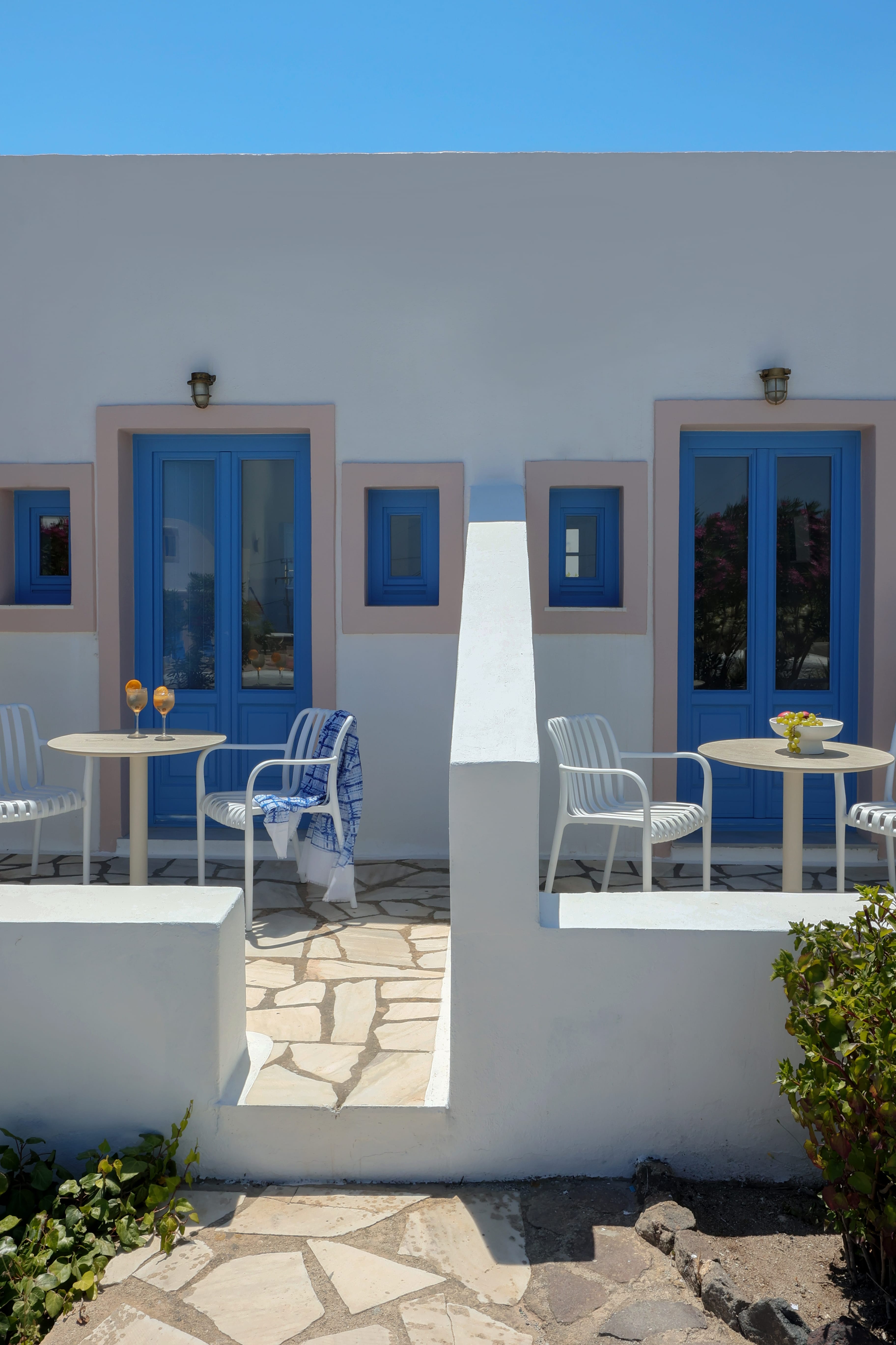 a white building with blue doors and tables