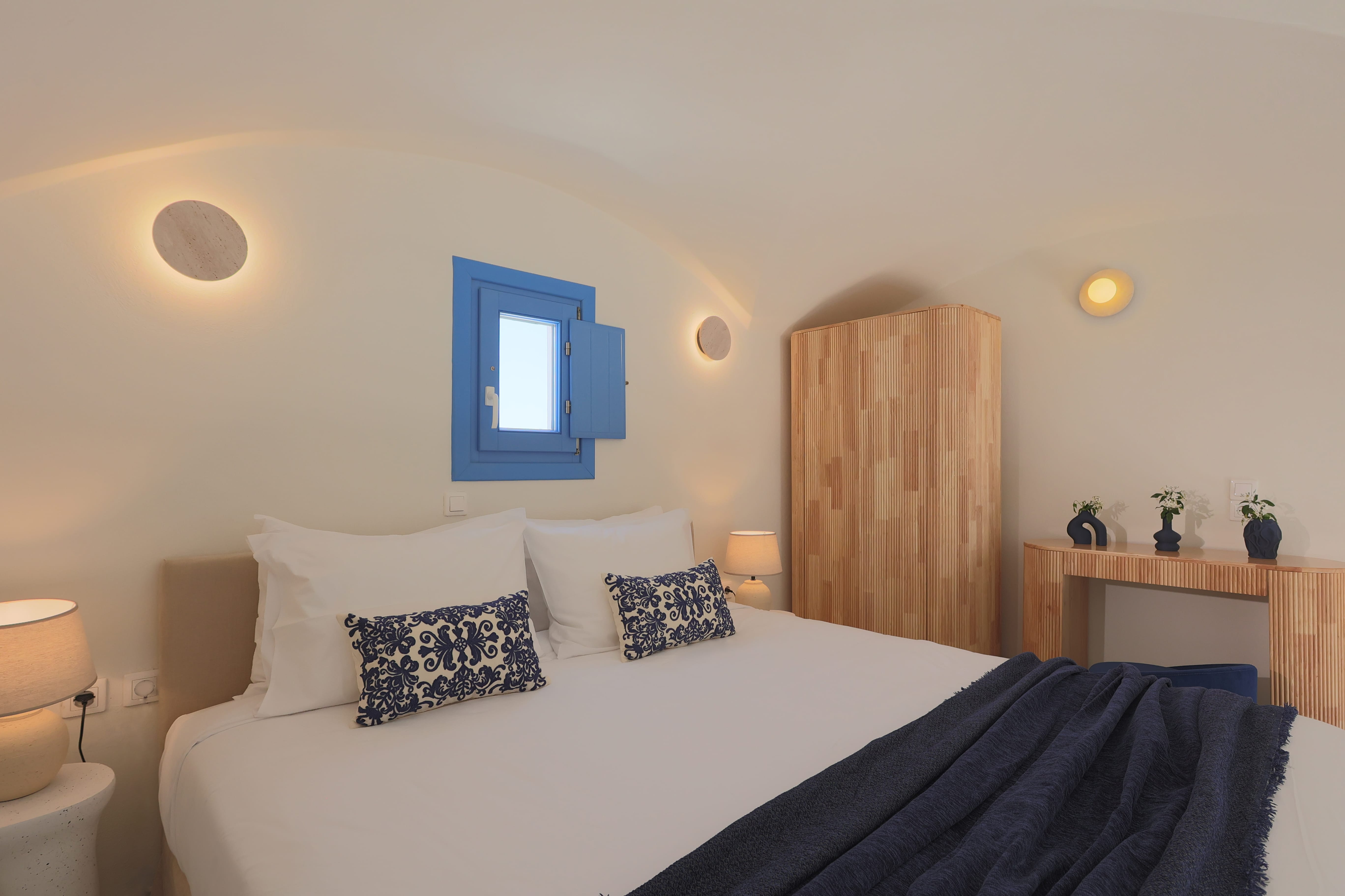 a bed with pillows and a blue blanket