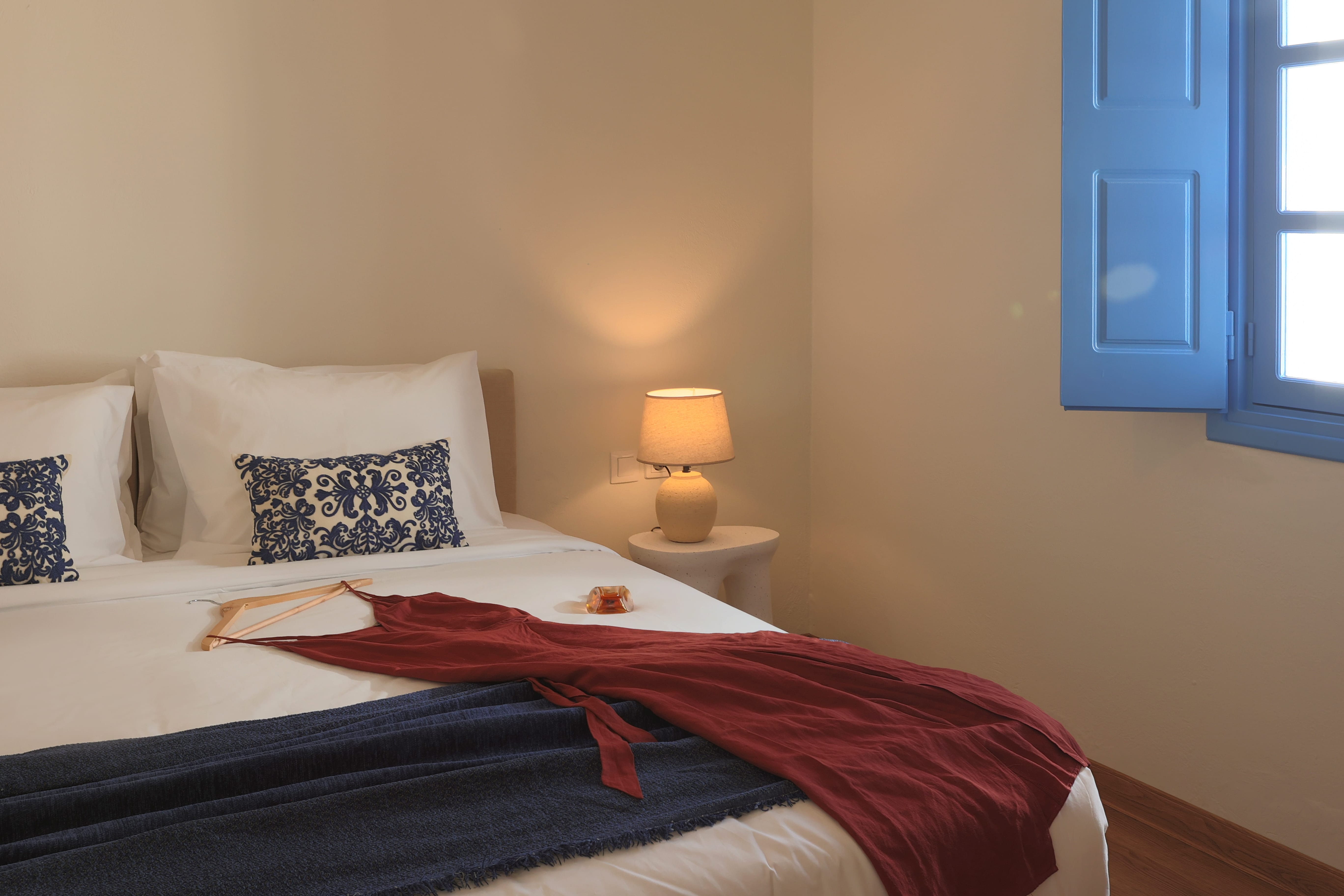 a bed with a red robe and a lamp