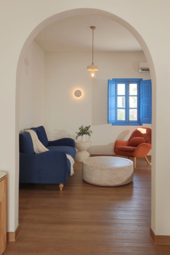 a room with a blue couch and a white table