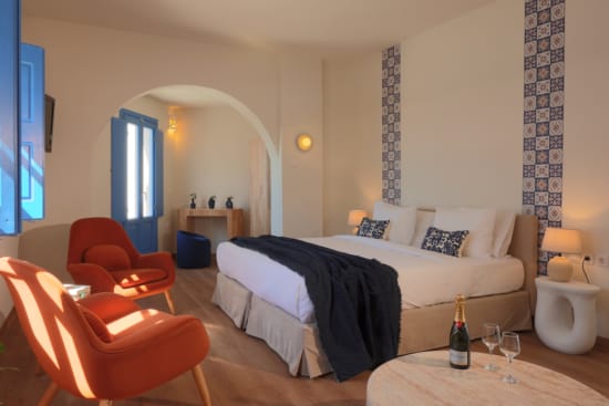 a bedroom with a bed and chairs