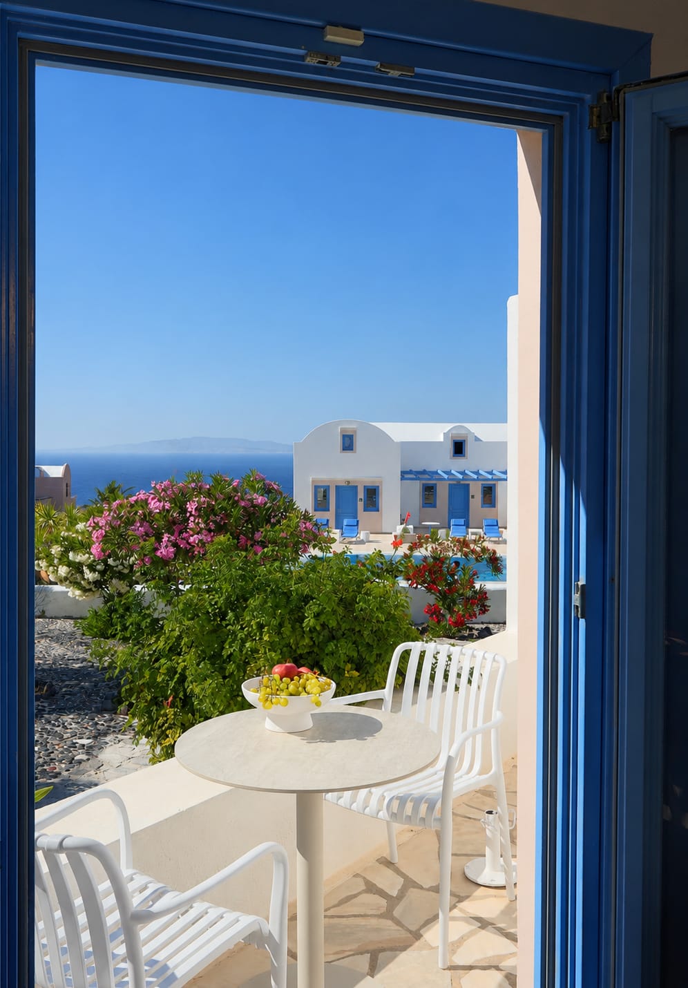 a white table and chairs outside a blue door