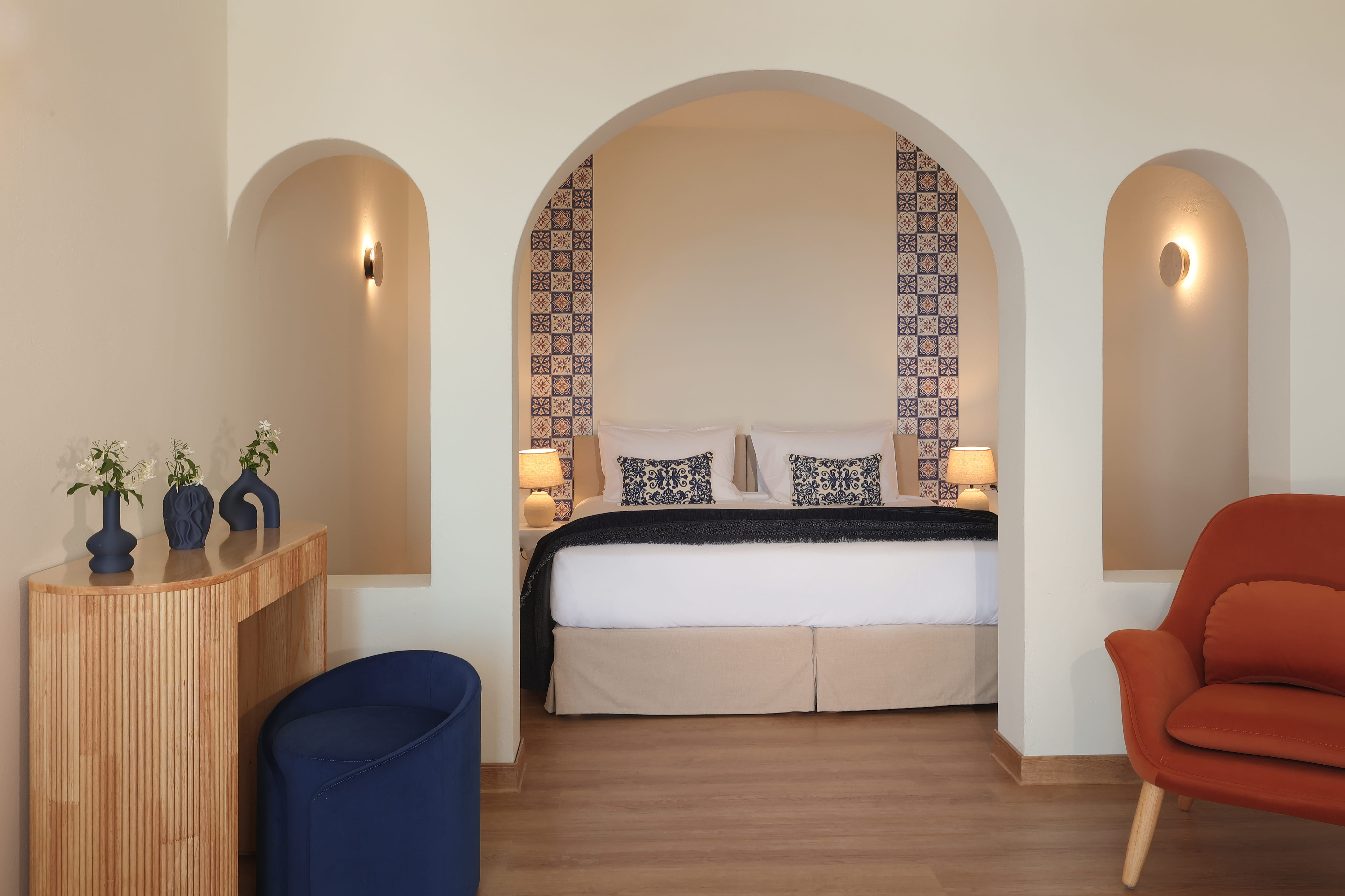 a bedroom with a bed and a blue stool