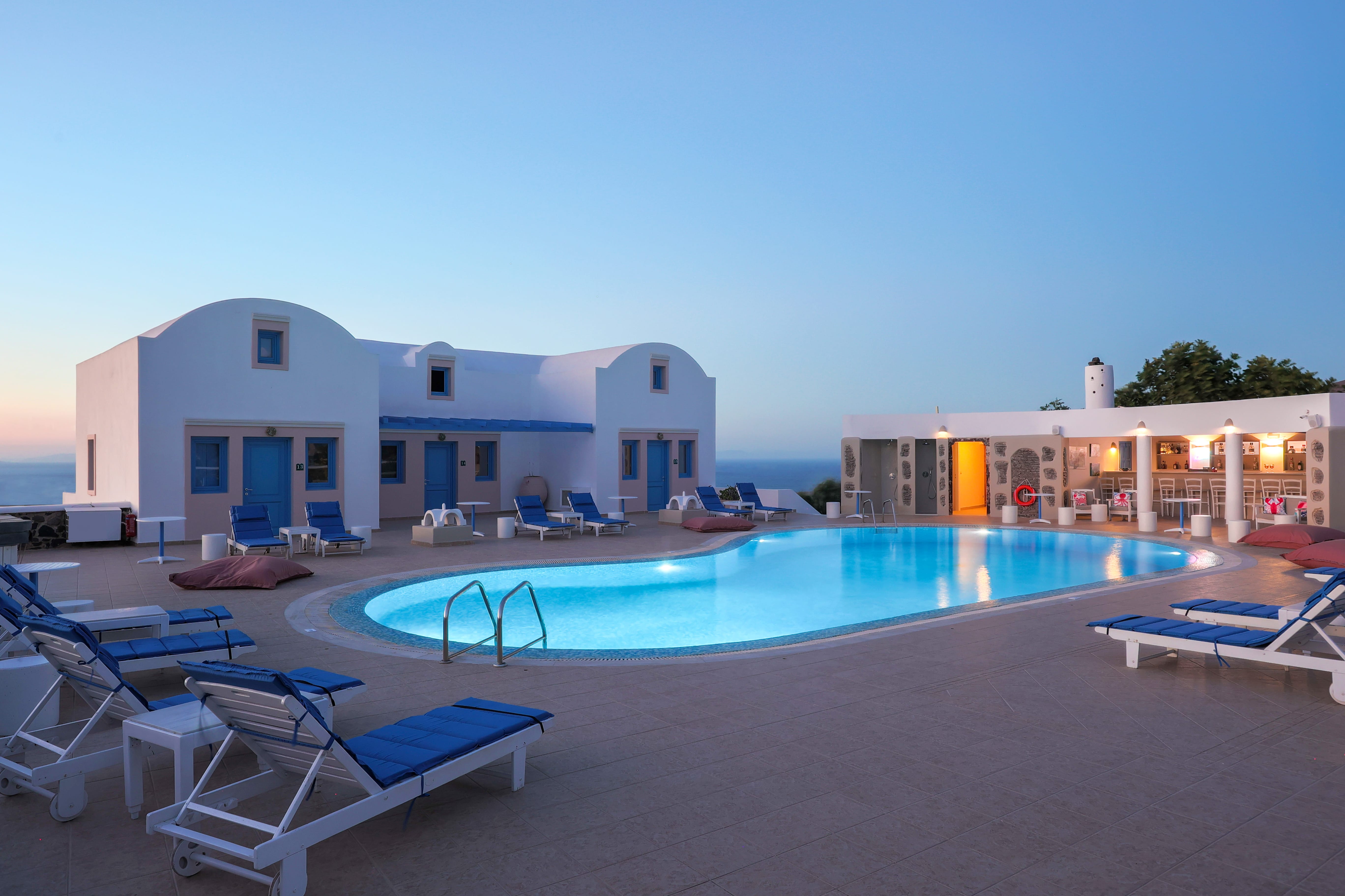 a swimming pool and lounge chairs in front of a house