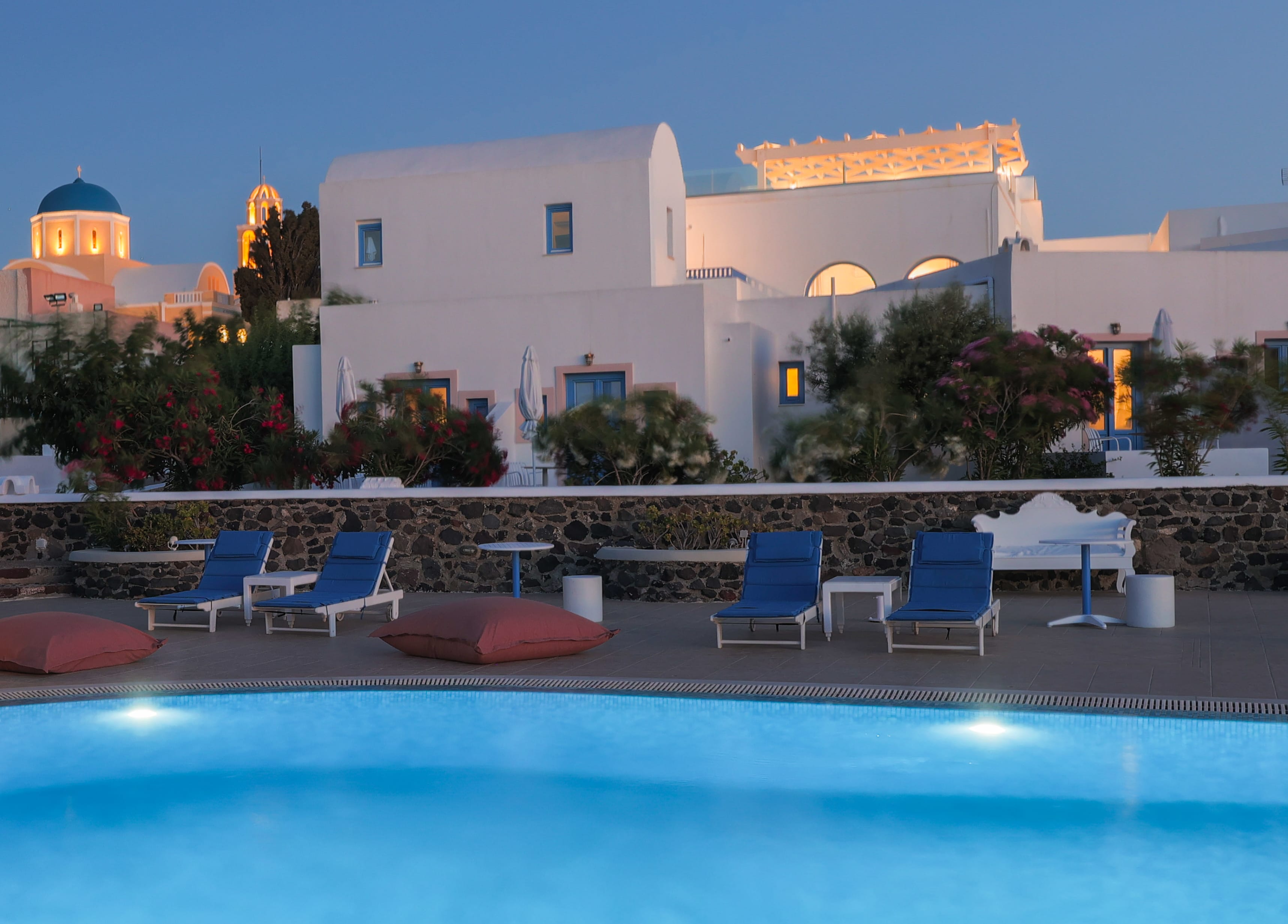 a pool with lounge chairs and a building in the background