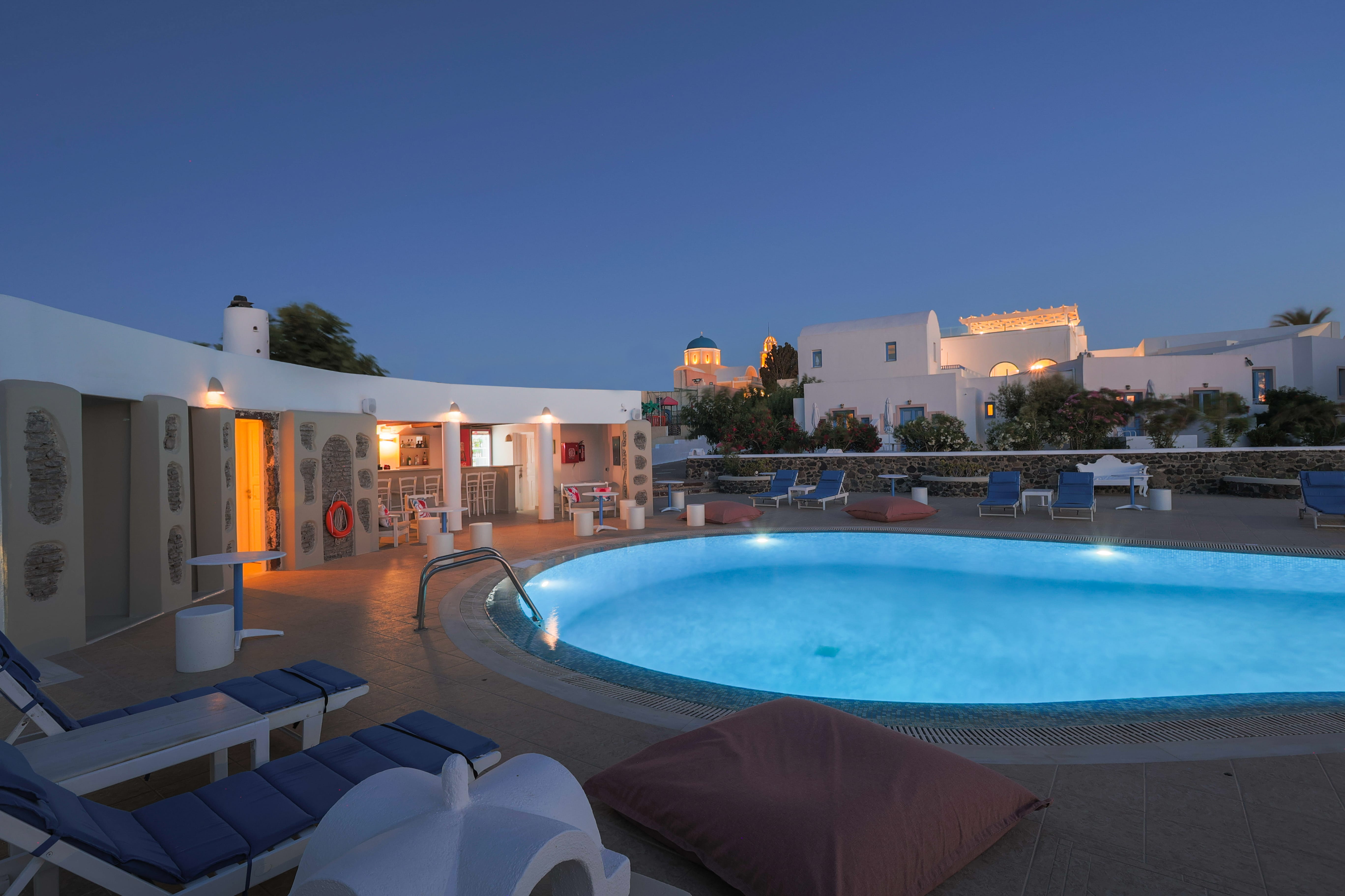 a pool with a deck chair and a building