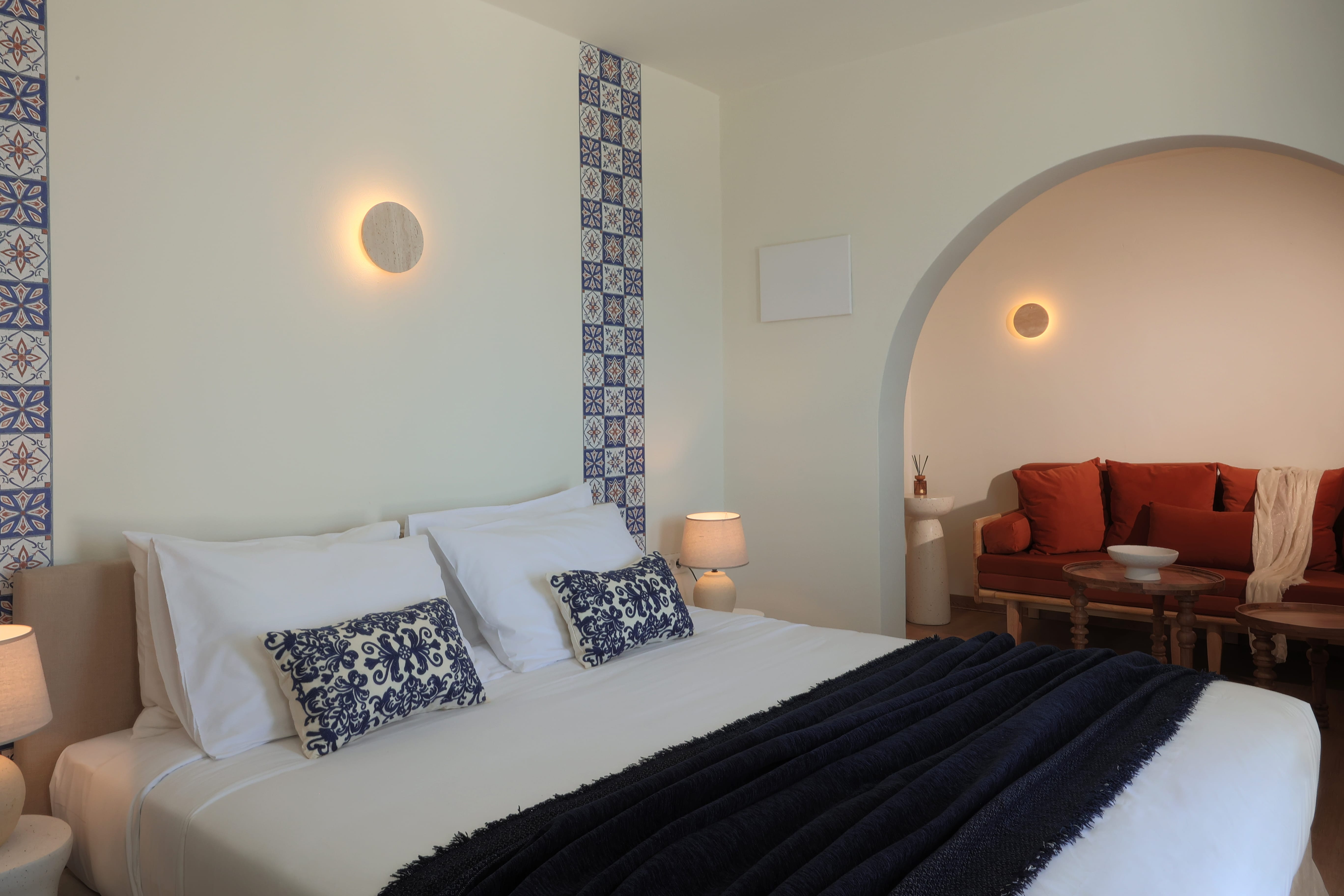 a bed with pillows and a chair in the background