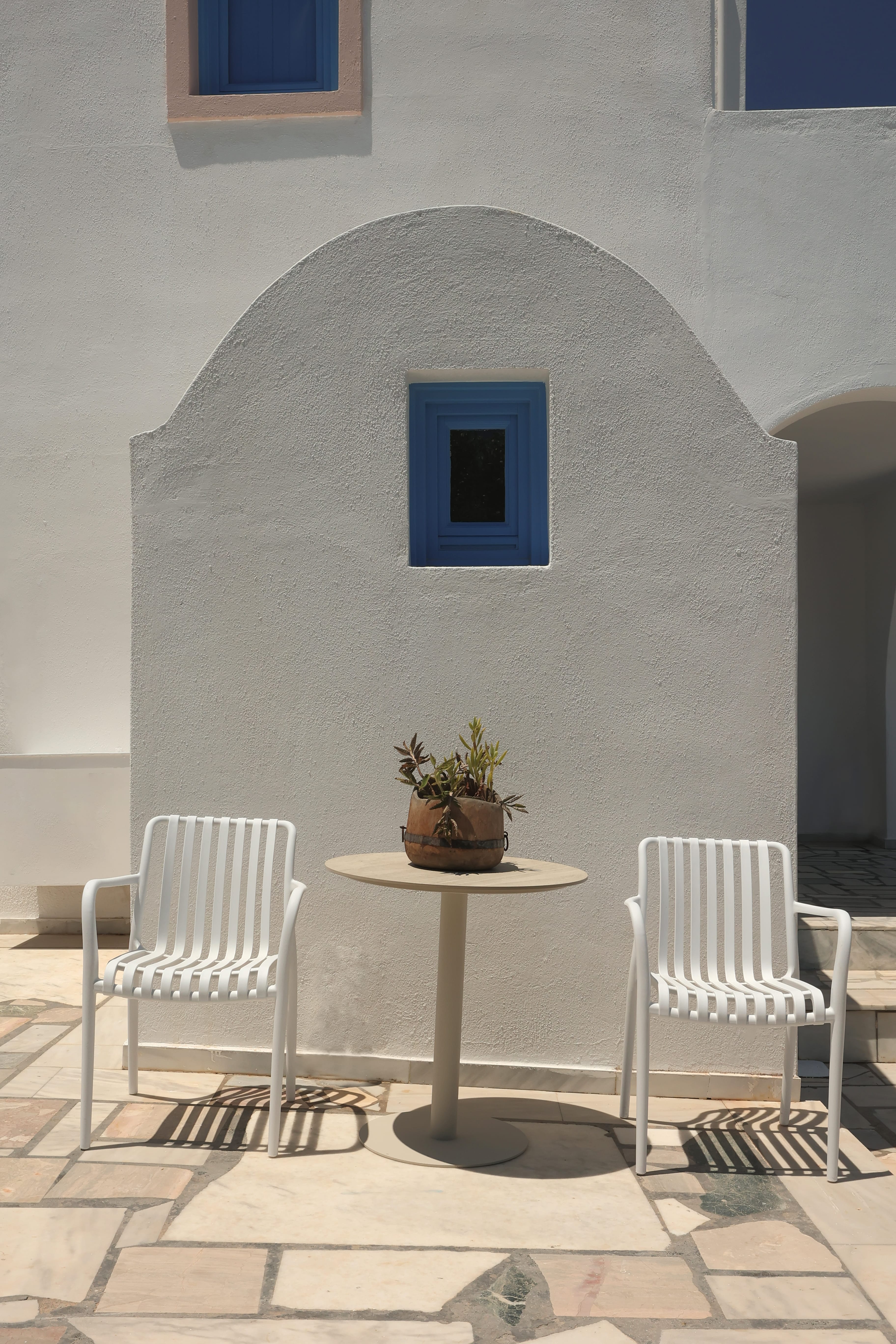 a white table and chairs in front of a white building
