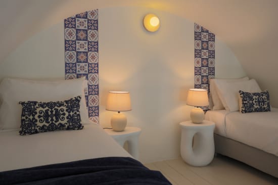 a bedroom with two beds and a lamp
