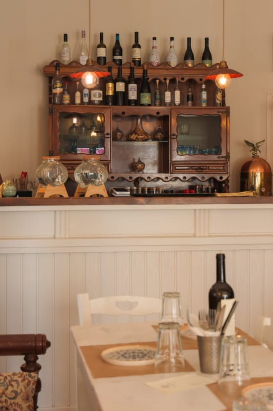 a table with a shelf and wine bottles