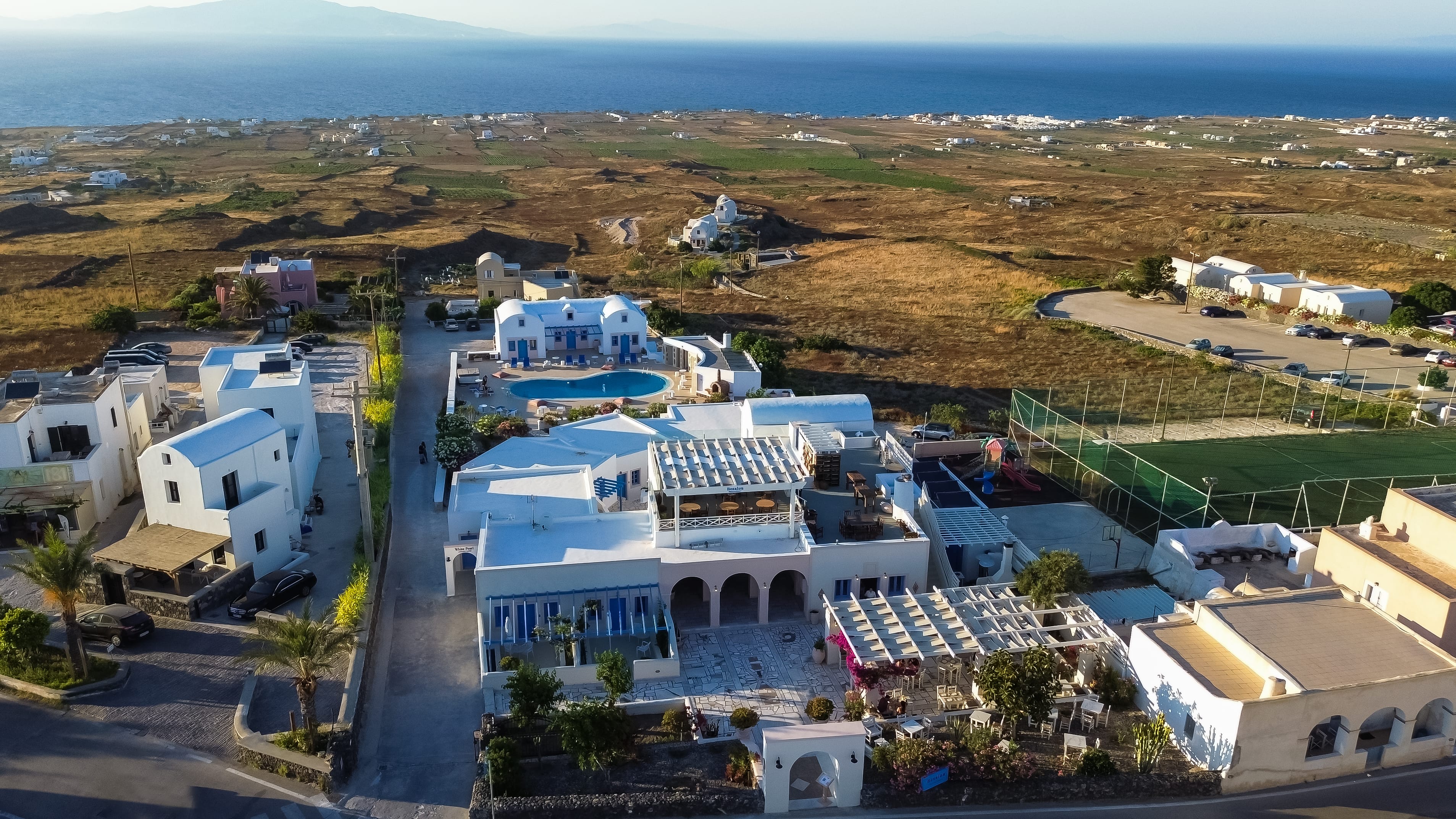 a large white building with a pool in the middle of a field