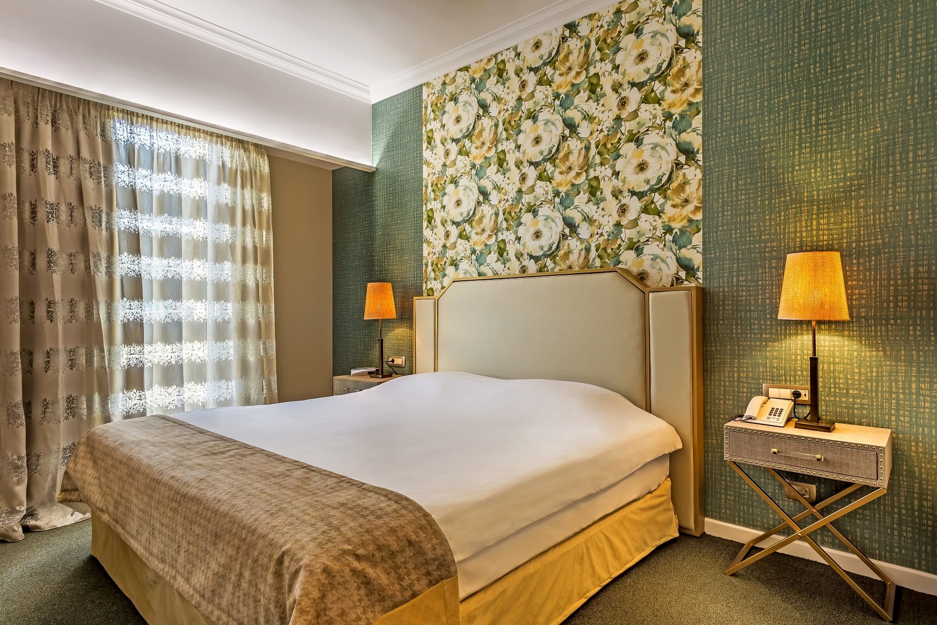 a bed with a floral wallpaper