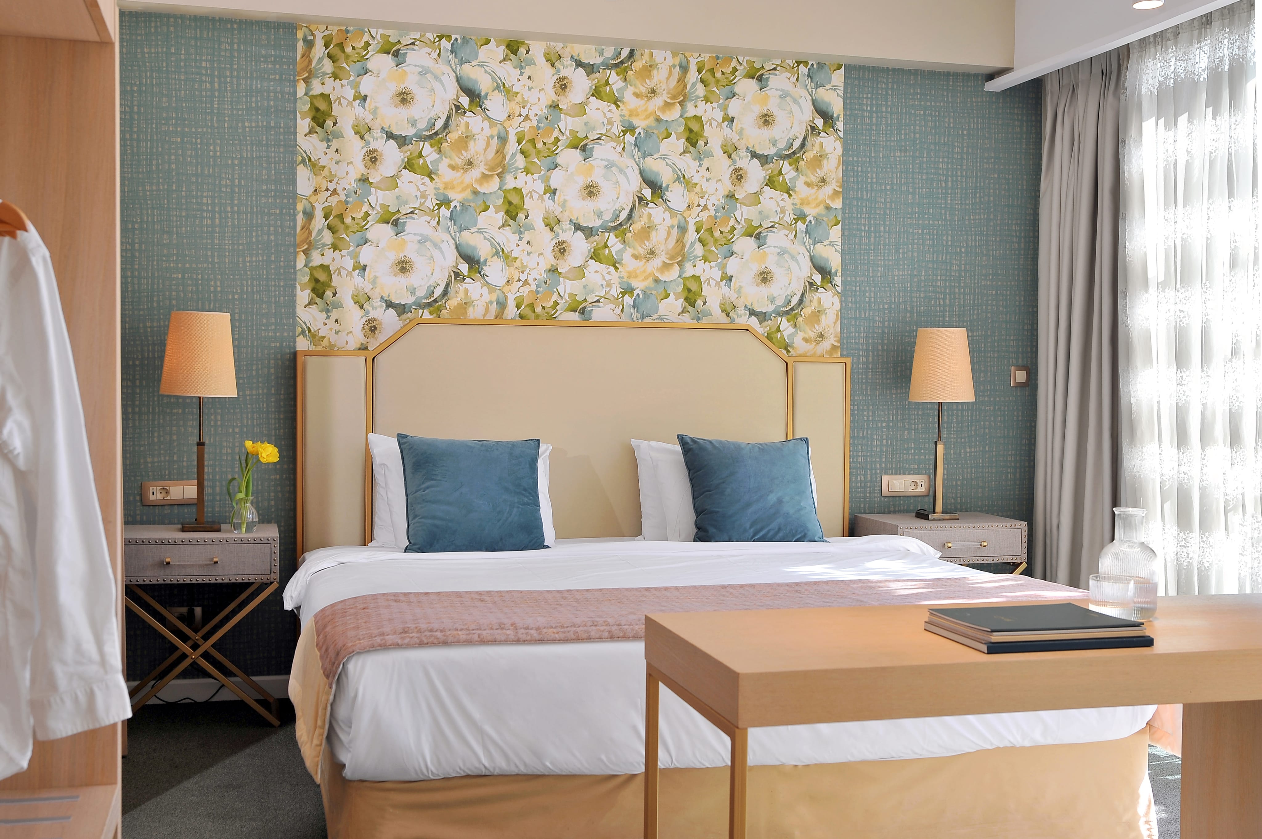 a bed with a floral wallpaper