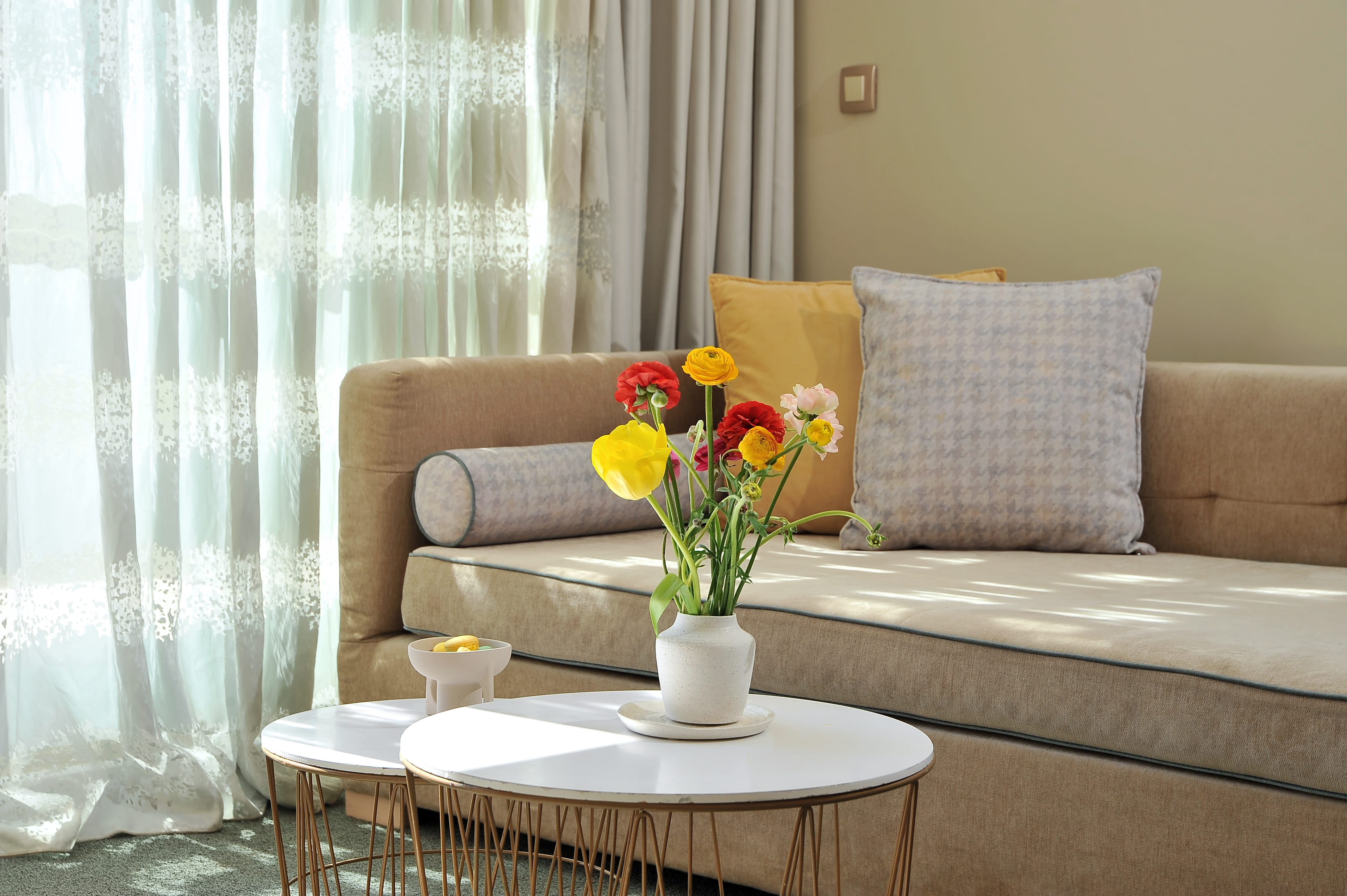 a vase of flowers on a table in front of a couch