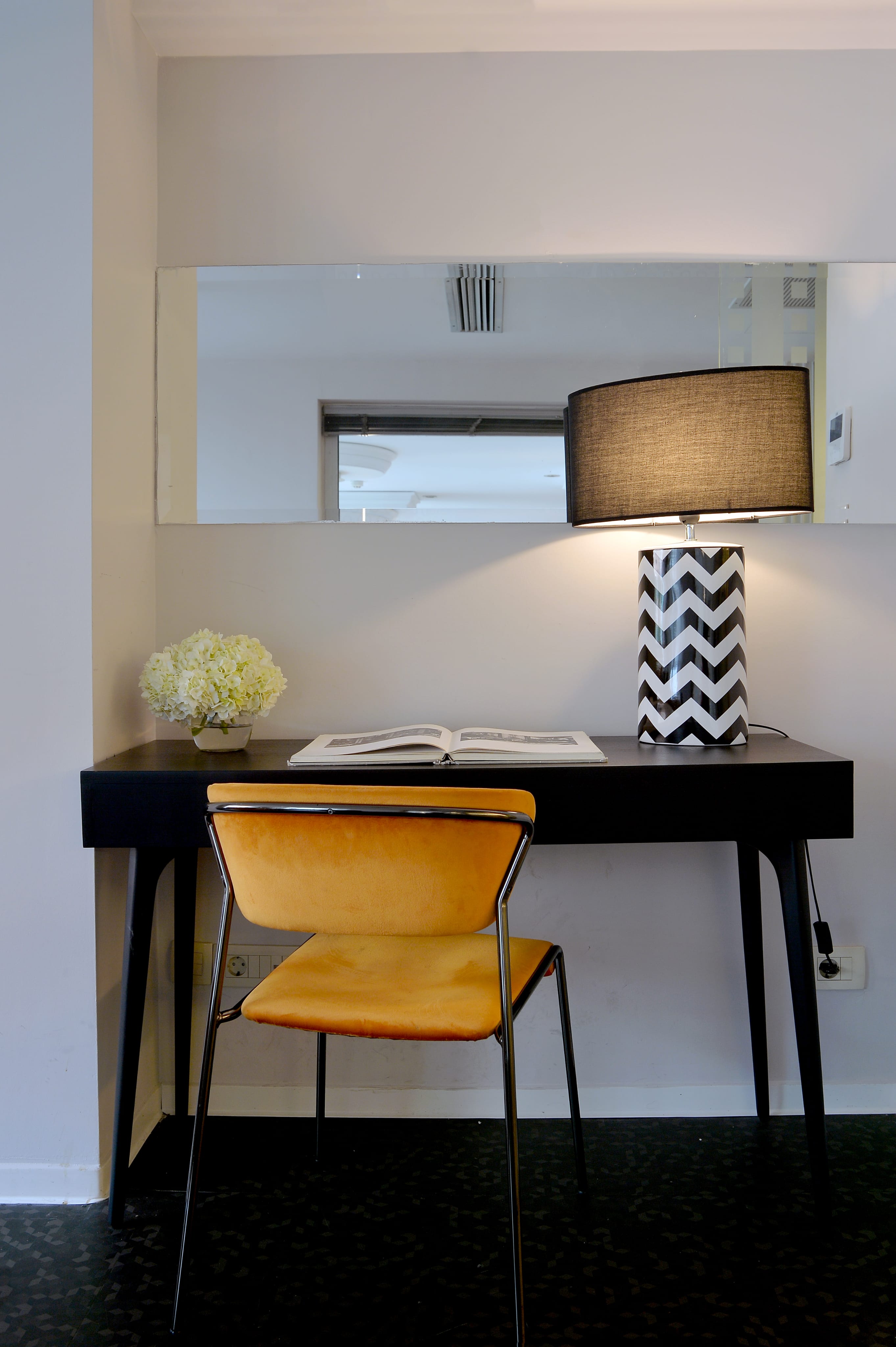 a desk with a lamp and a chair