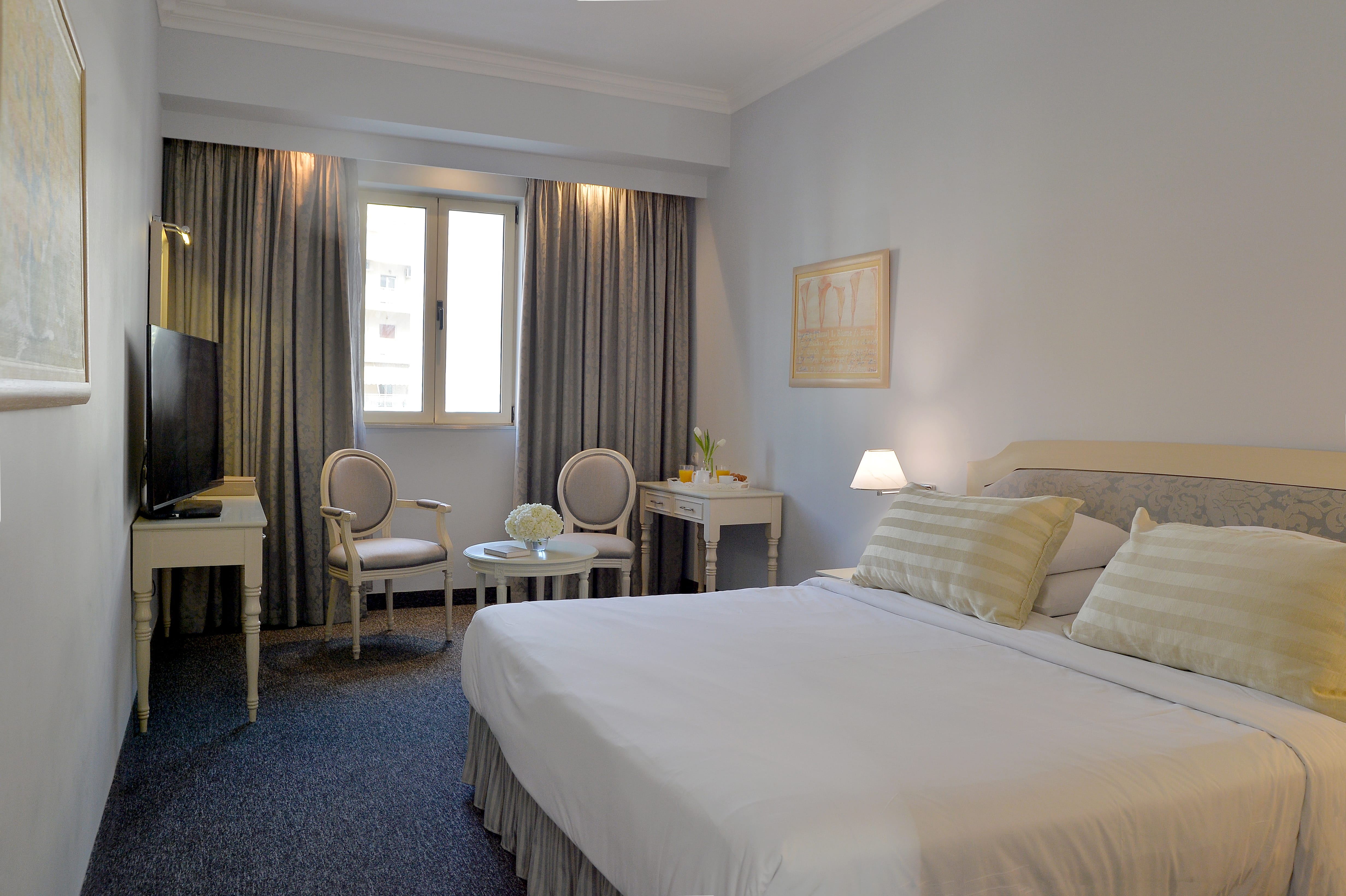 a bedroom with a bed and chairs