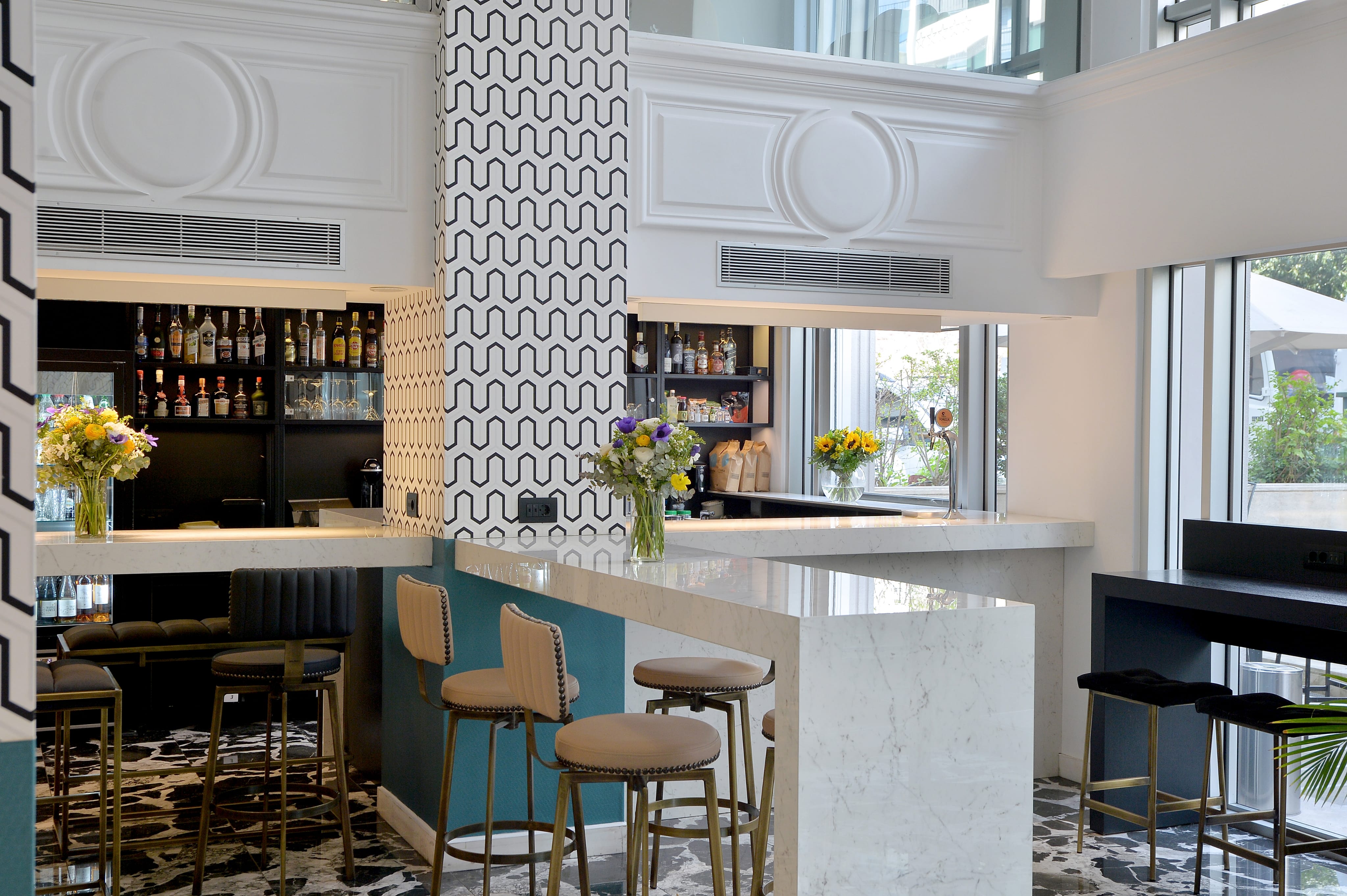 a bar with stools and a vase of flowers