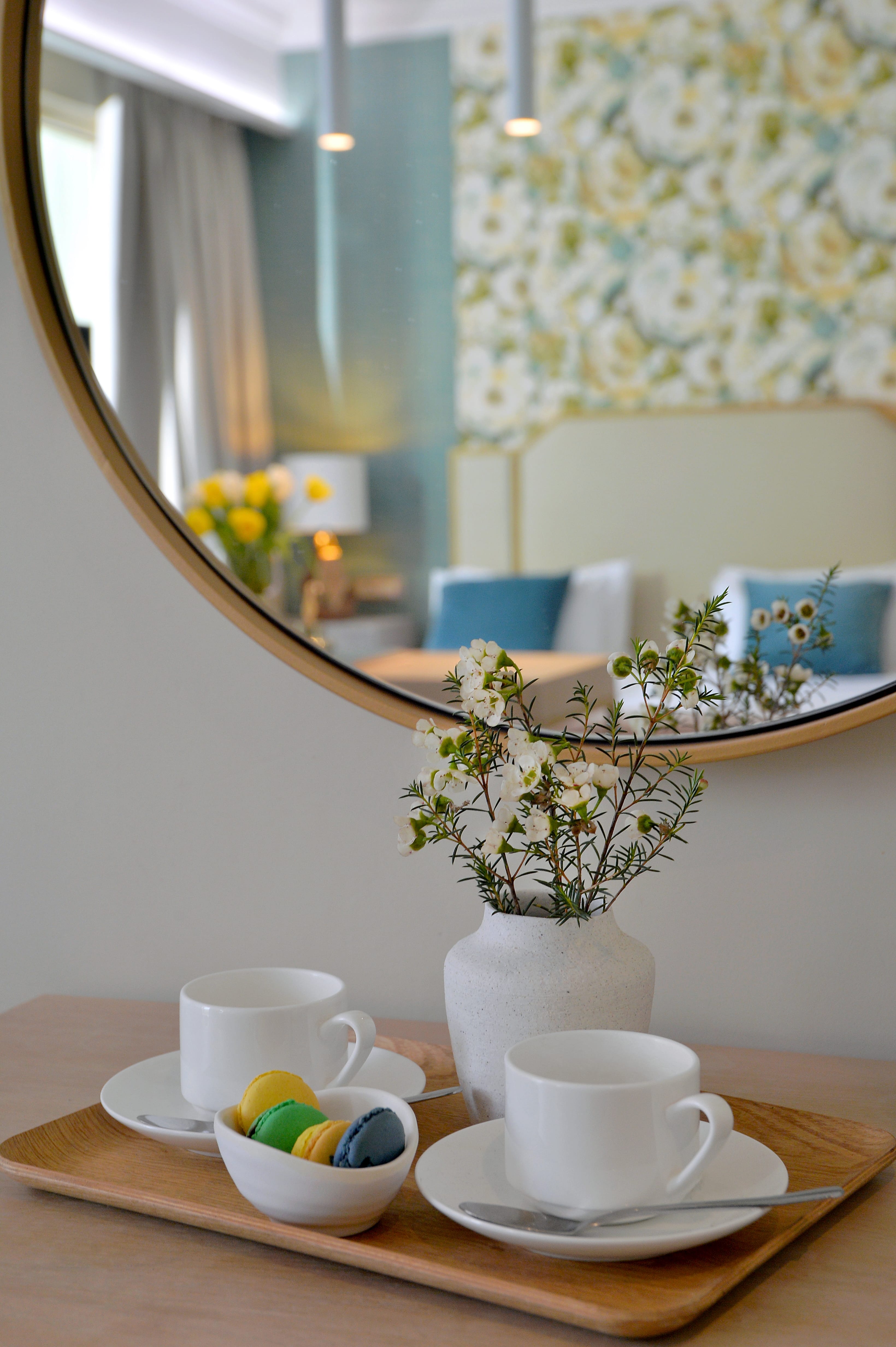 a tray with cups and a vase of flowers on it