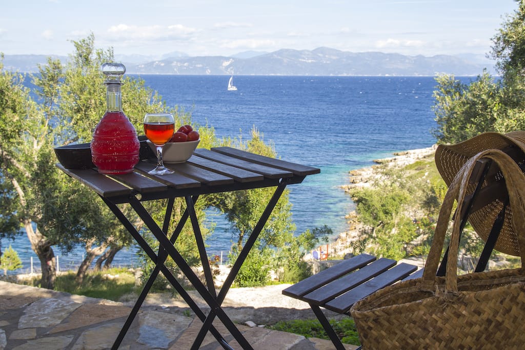 a table with glasses of wine on it overlooking a body of water