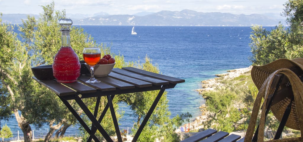 a table with glasses of wine on it overlooking a body of water