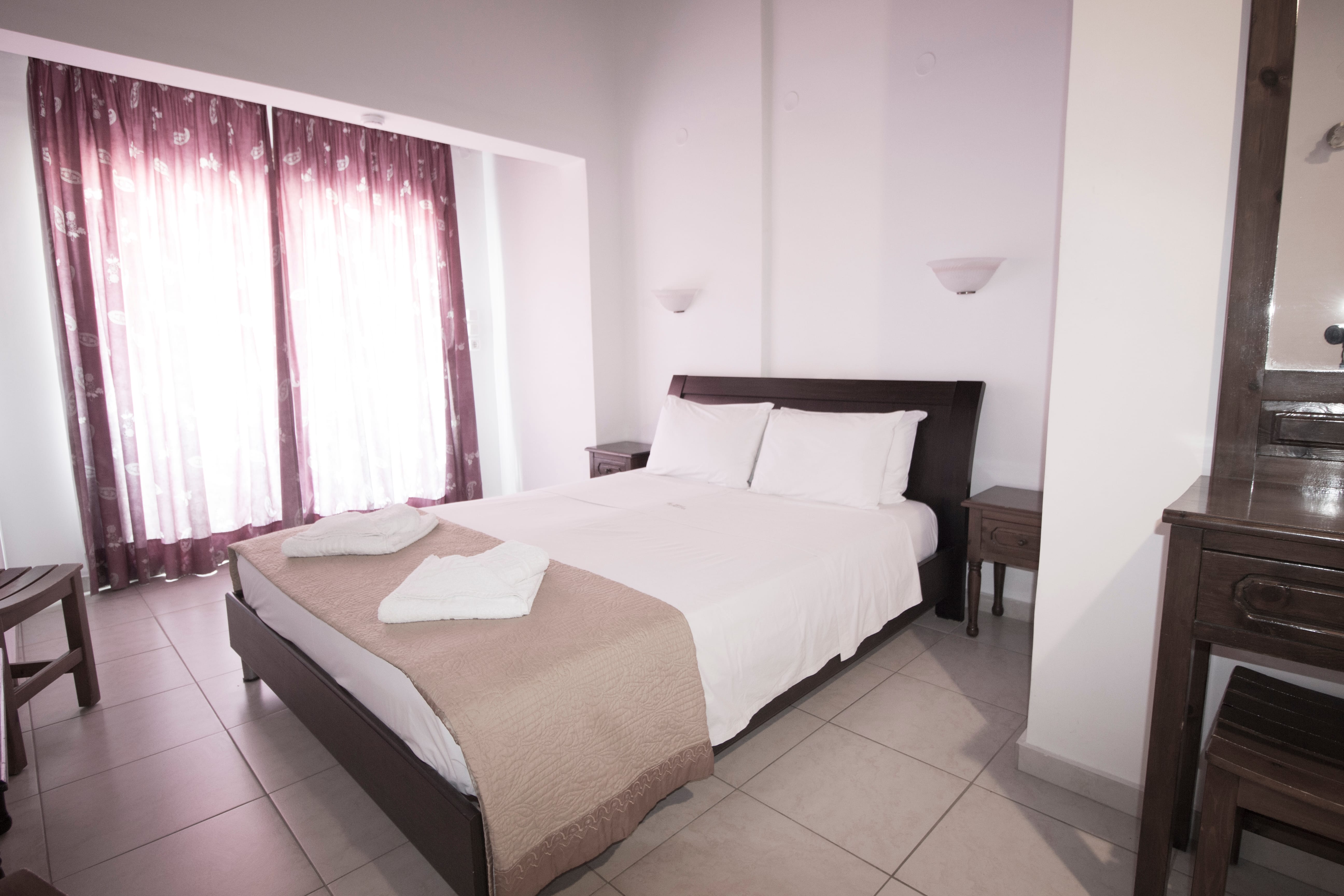 a bed with white sheets and brown bedding