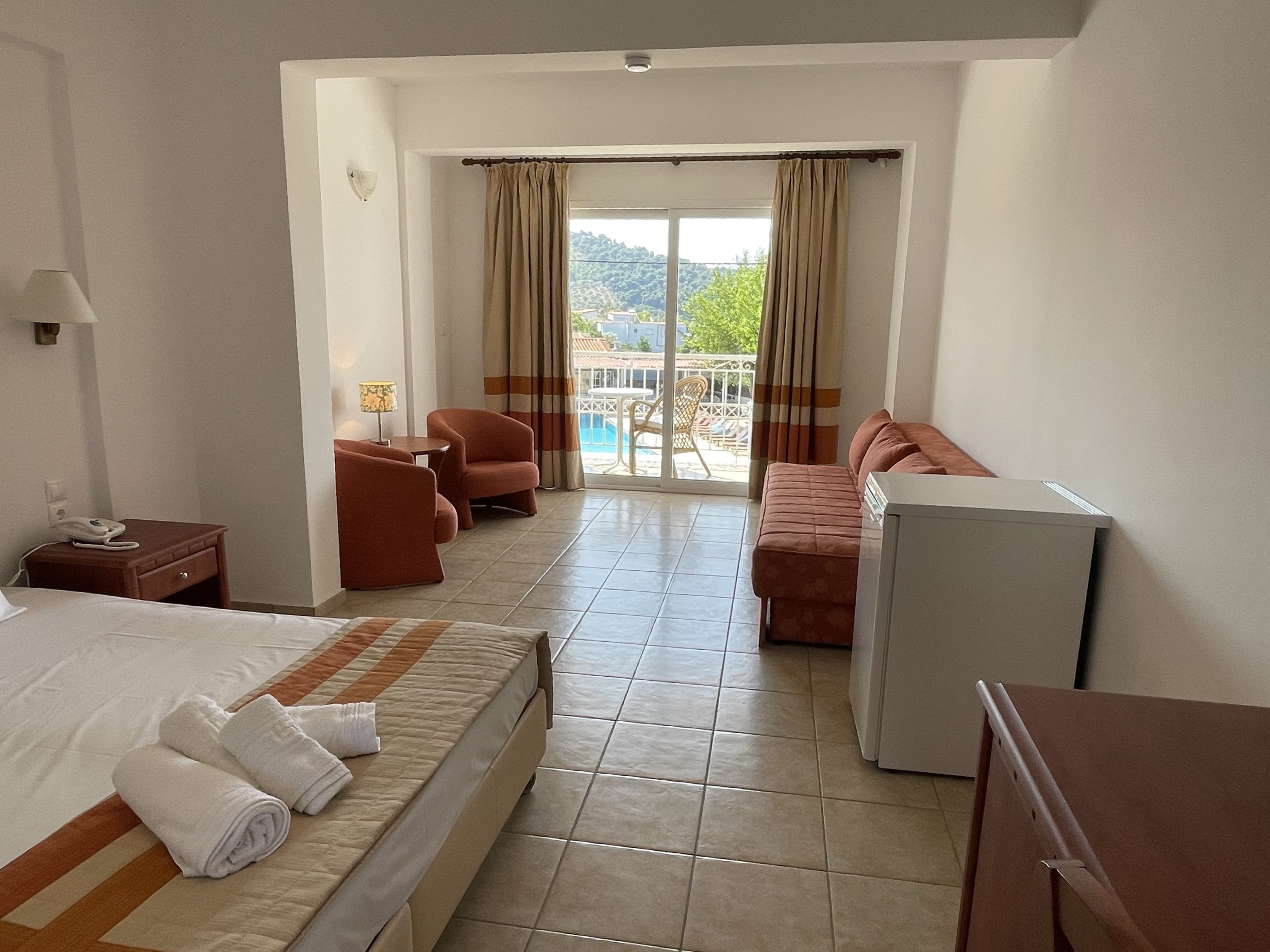 a room with a bed and chairs