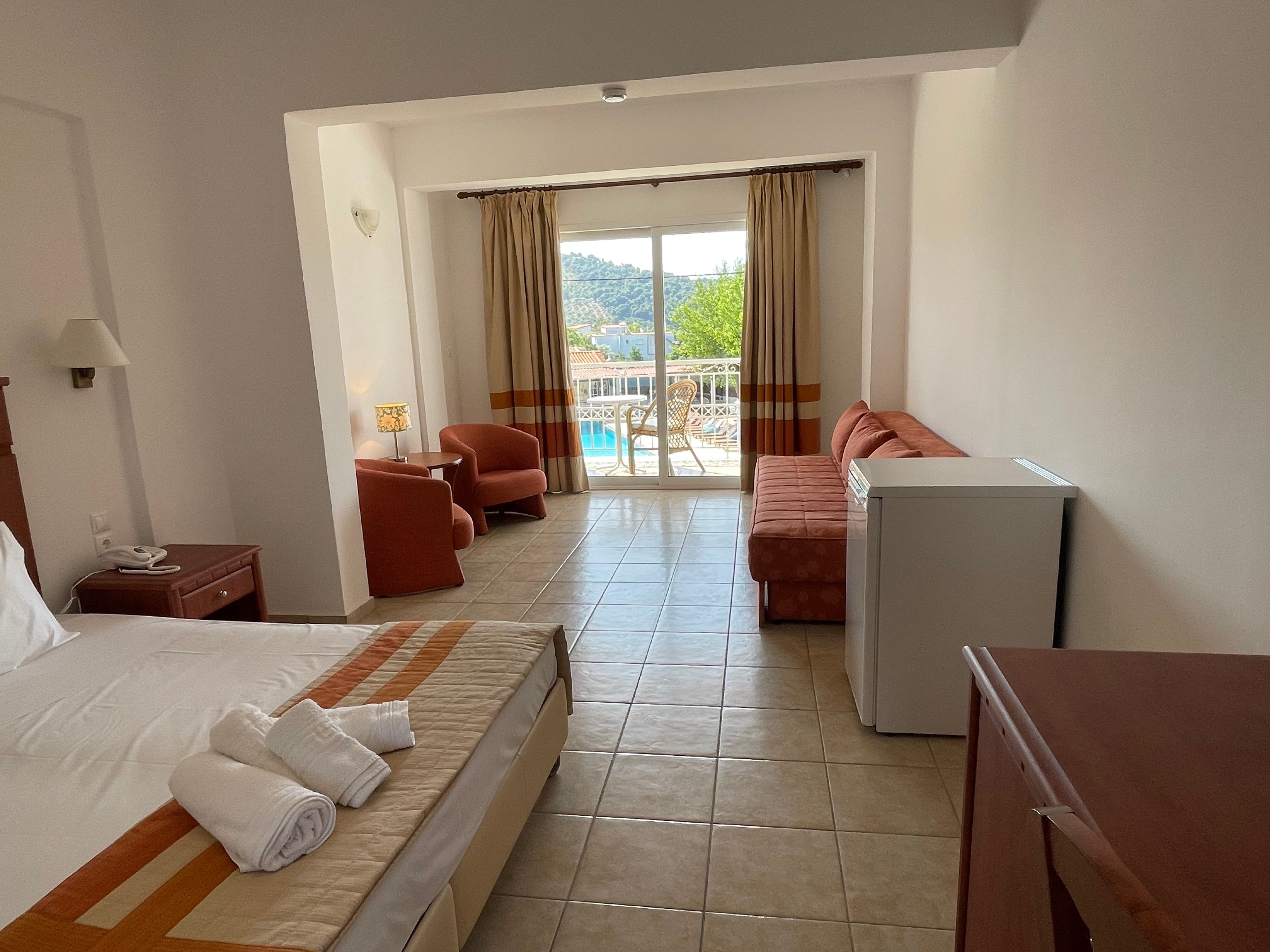 a room with a bed and chairs