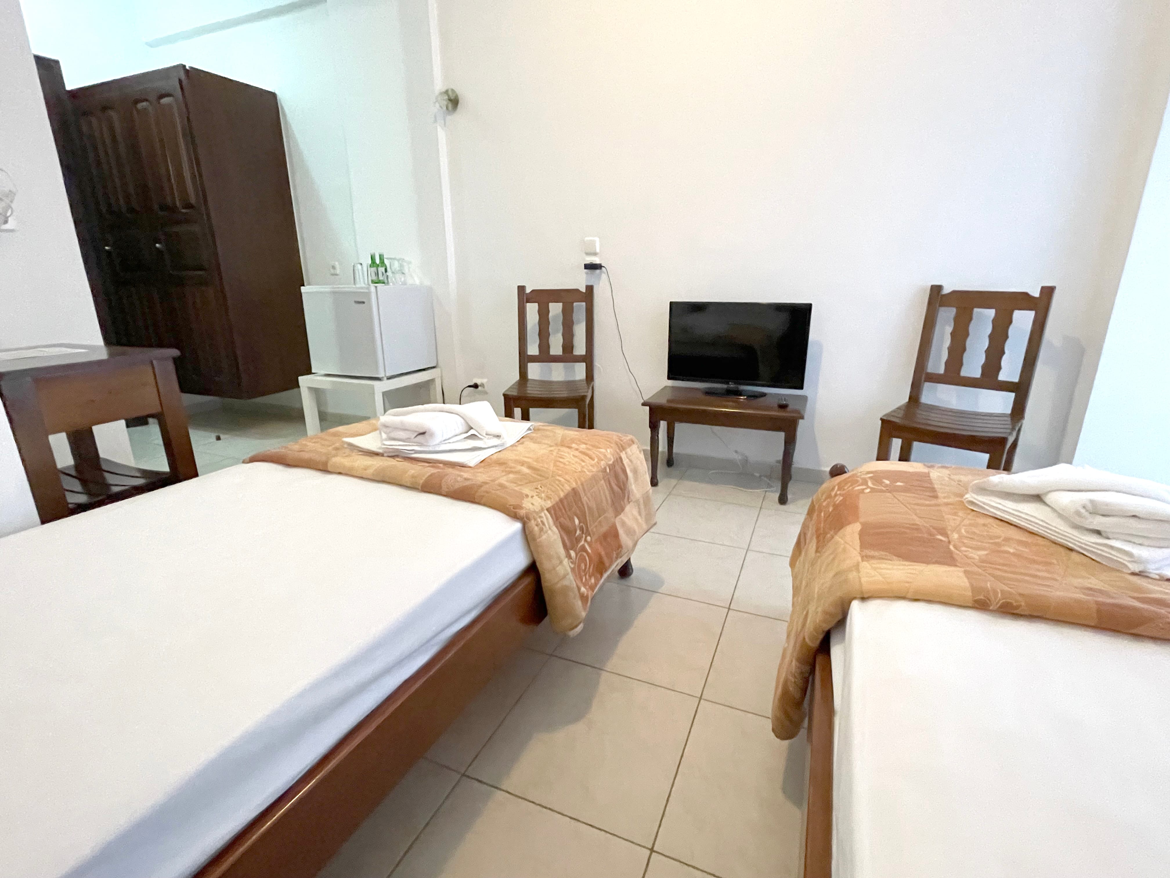 a room with two beds and a television