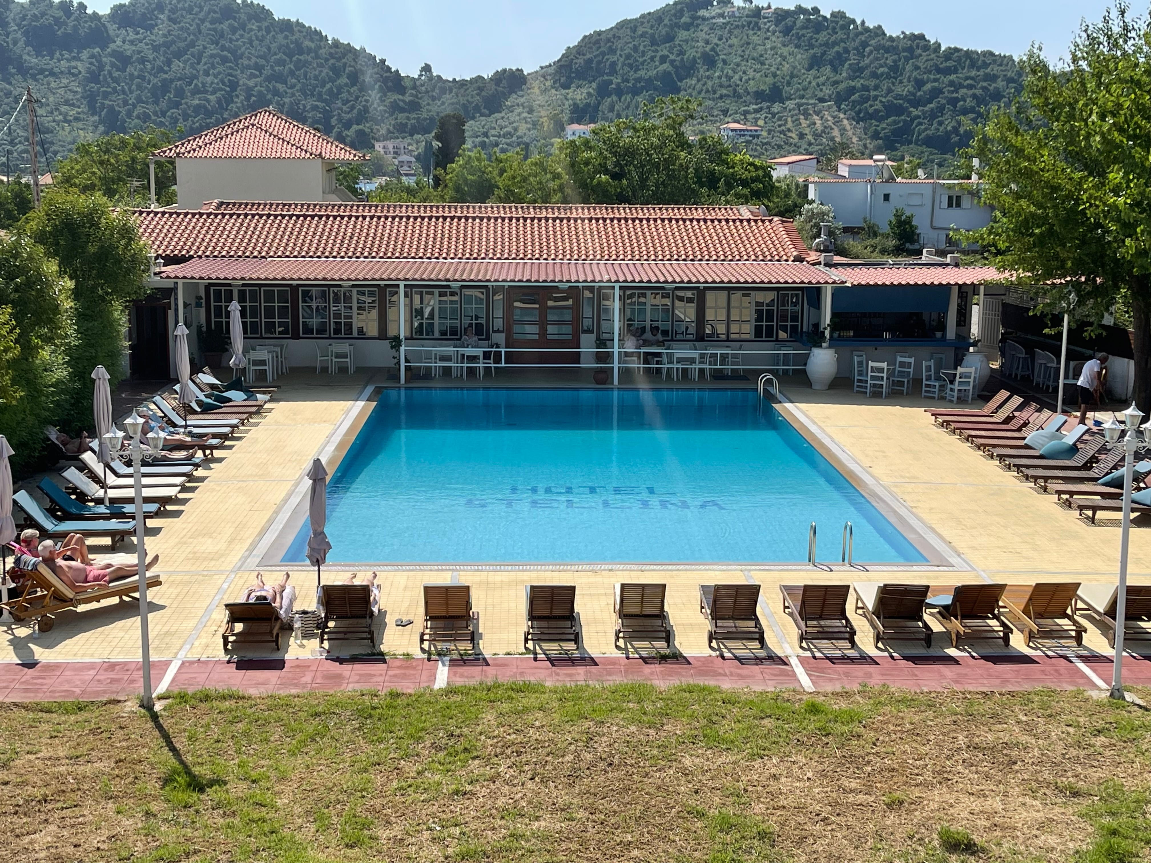 a swimming pool with chairs and a building