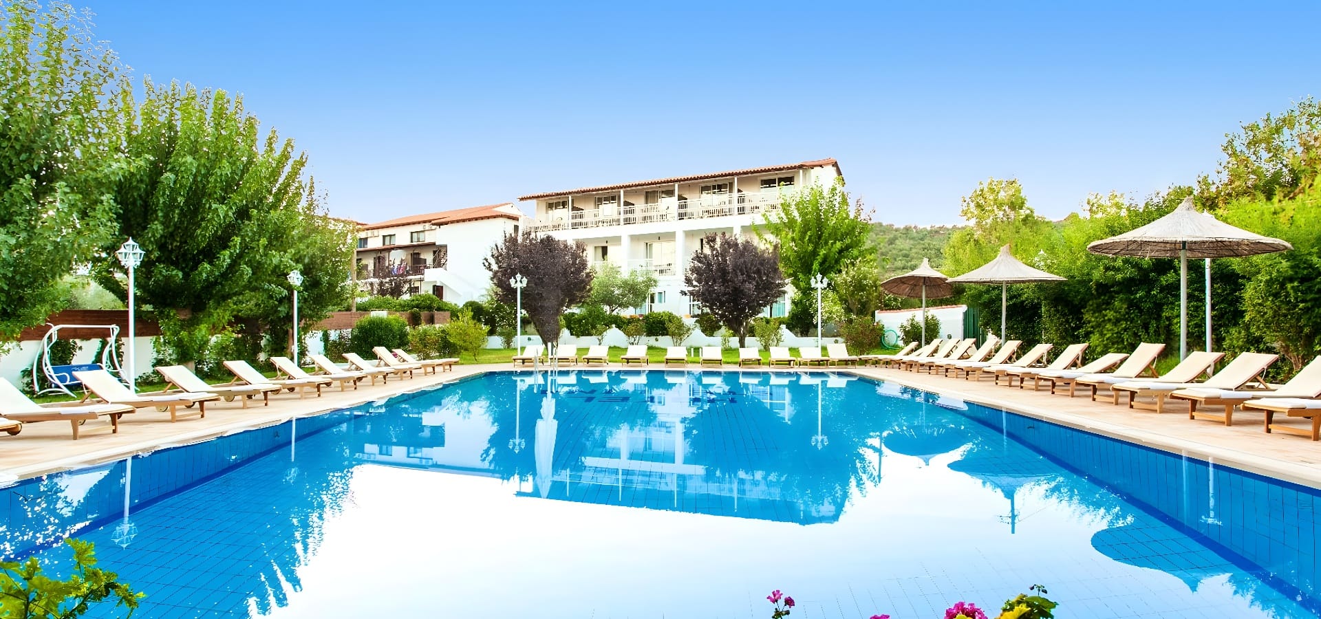a pool with chairs and trees in the background