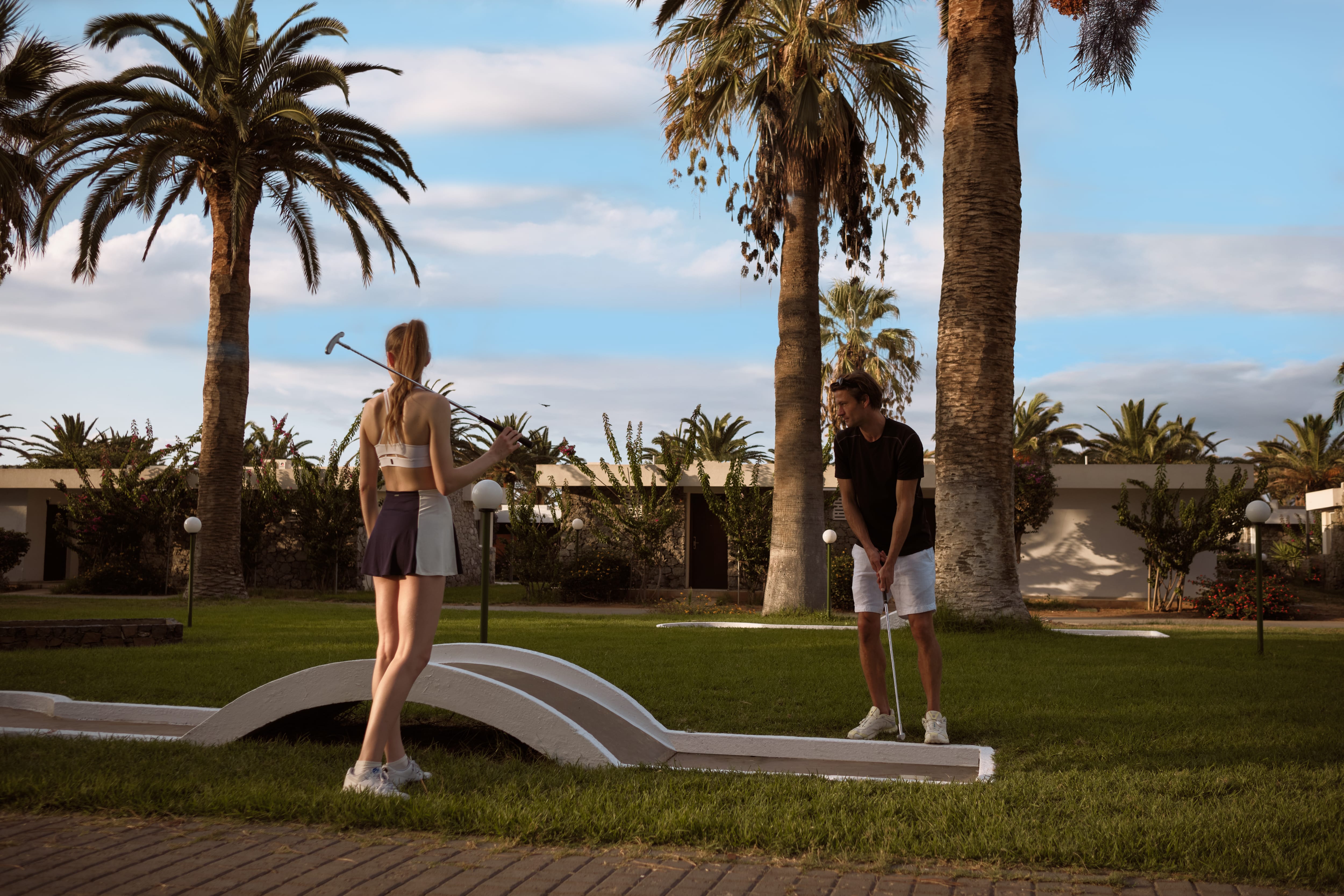 a person and person playing mini golf