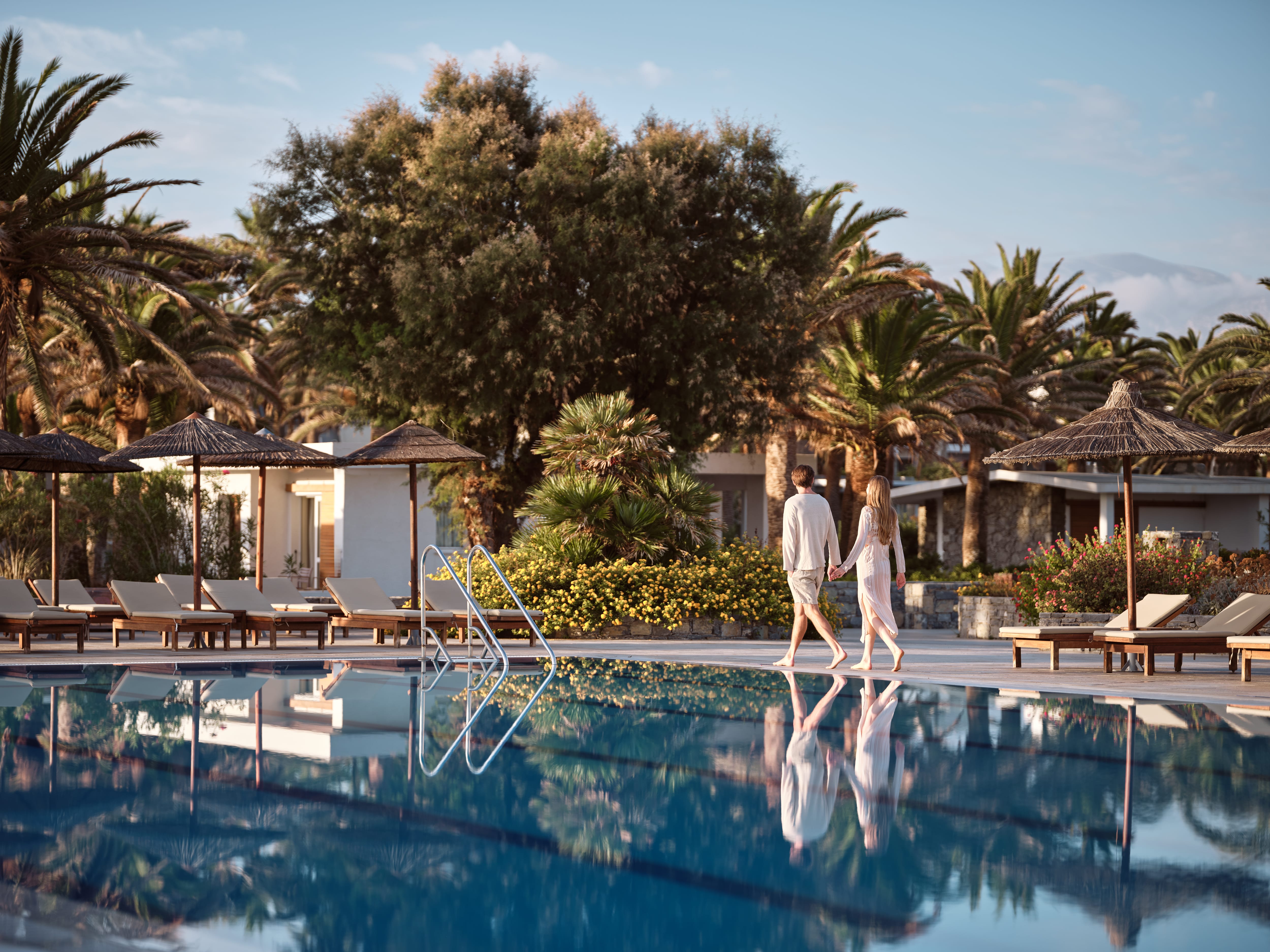 a person and person walking by a pool