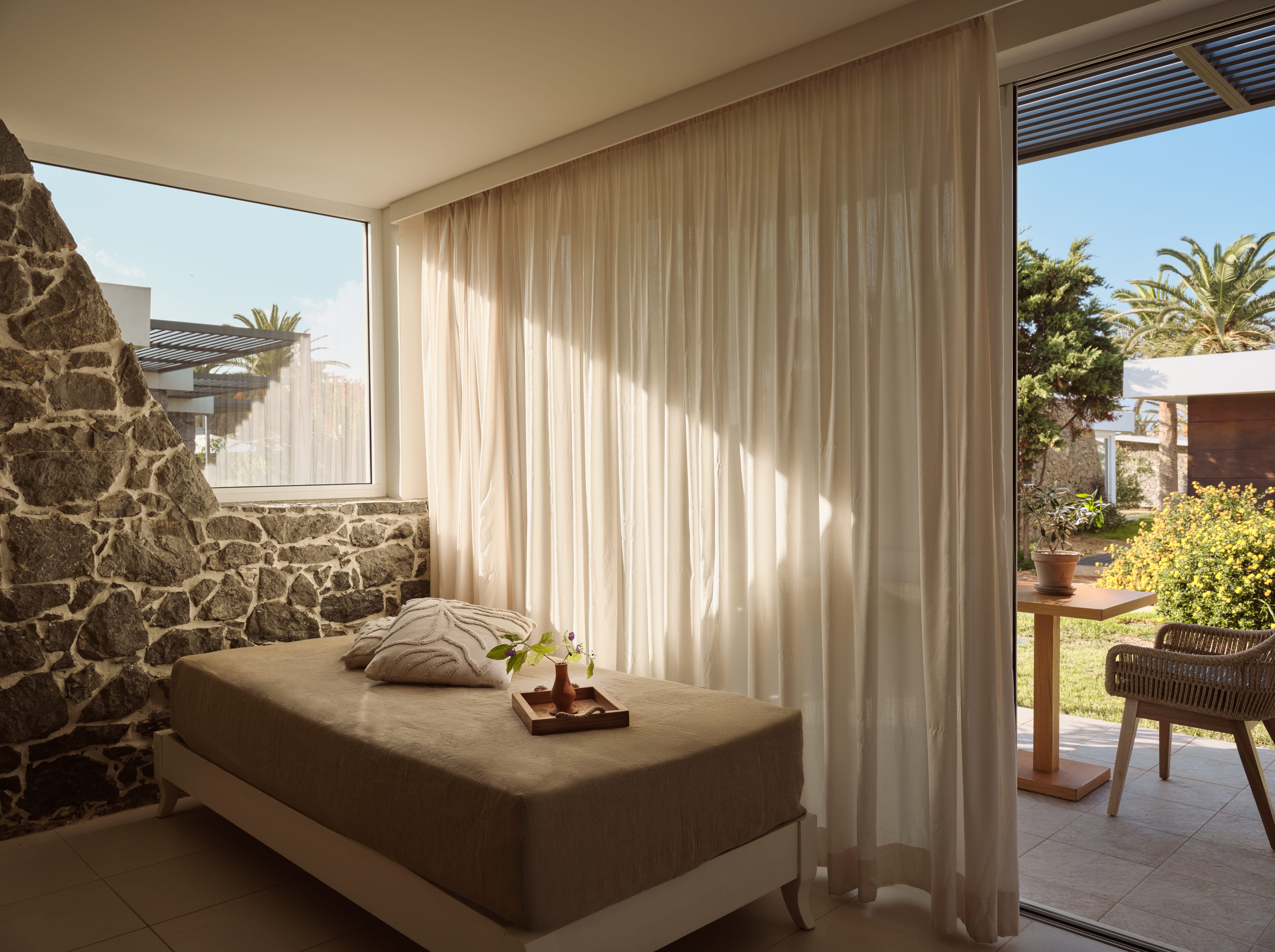 a bedroom with a stone wall and a bed