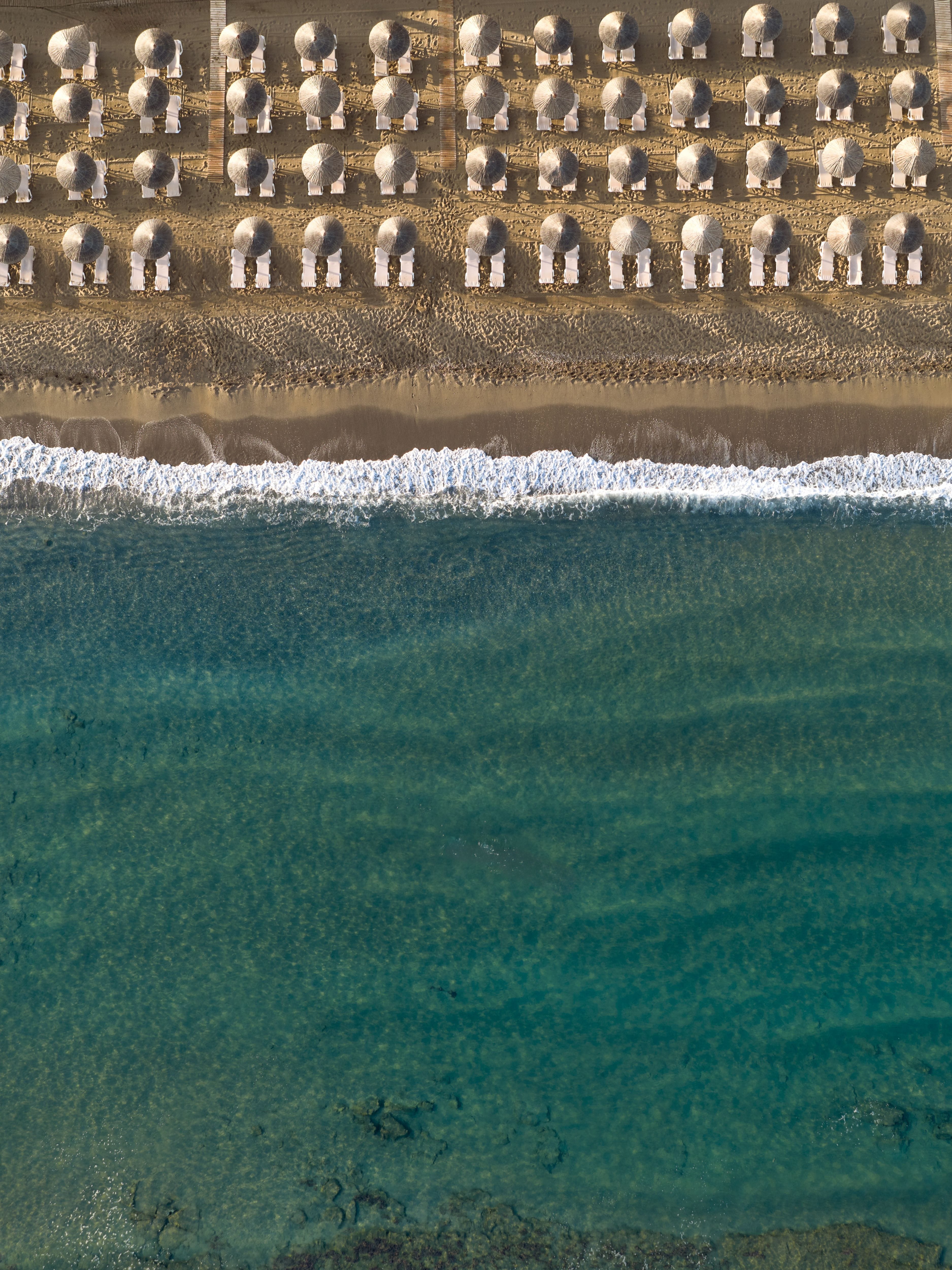 aerial view of a beach with umbrellas and chairs