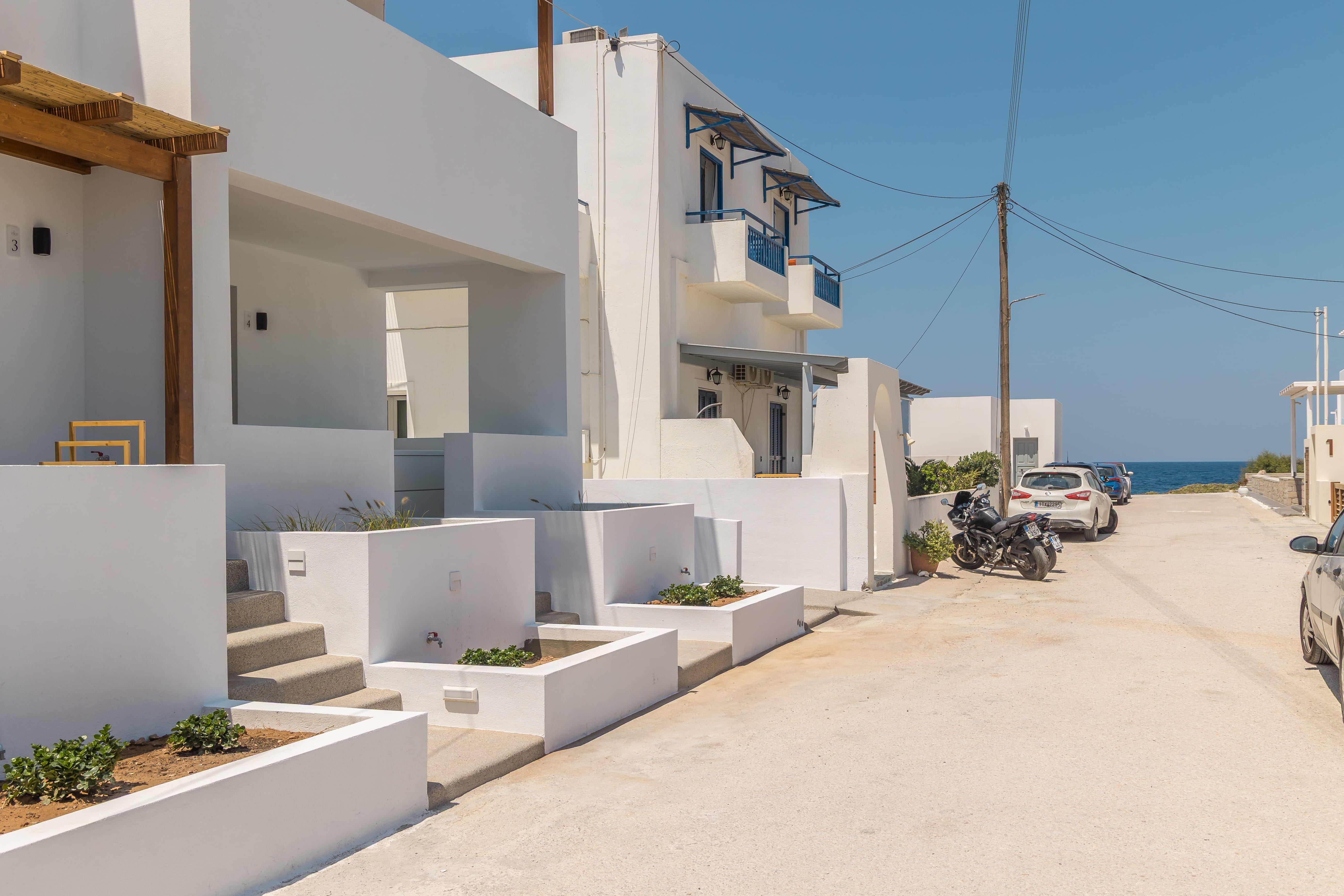 a street with white buildings and a motorcycle