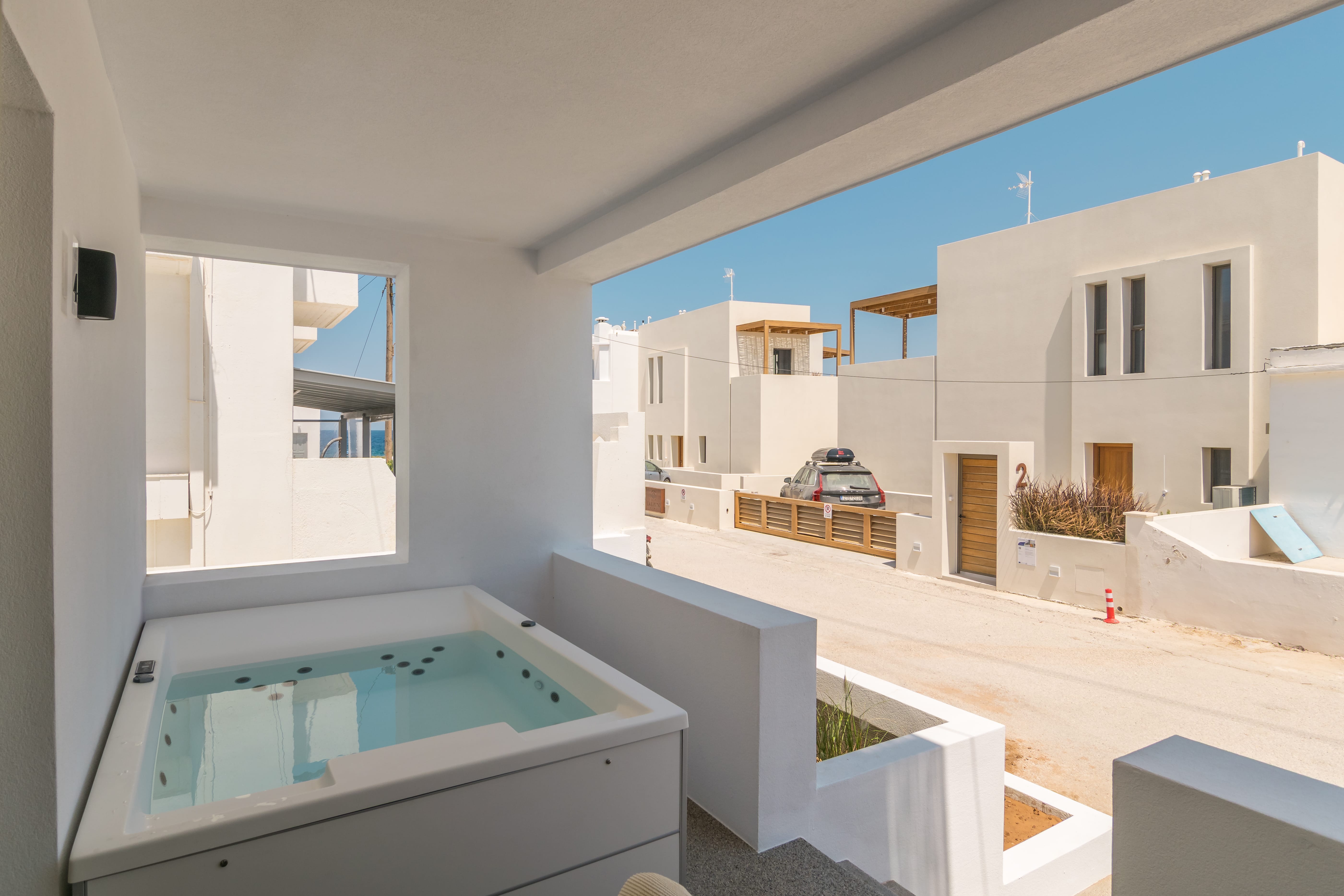 a white room with a hot tub and a street in the background