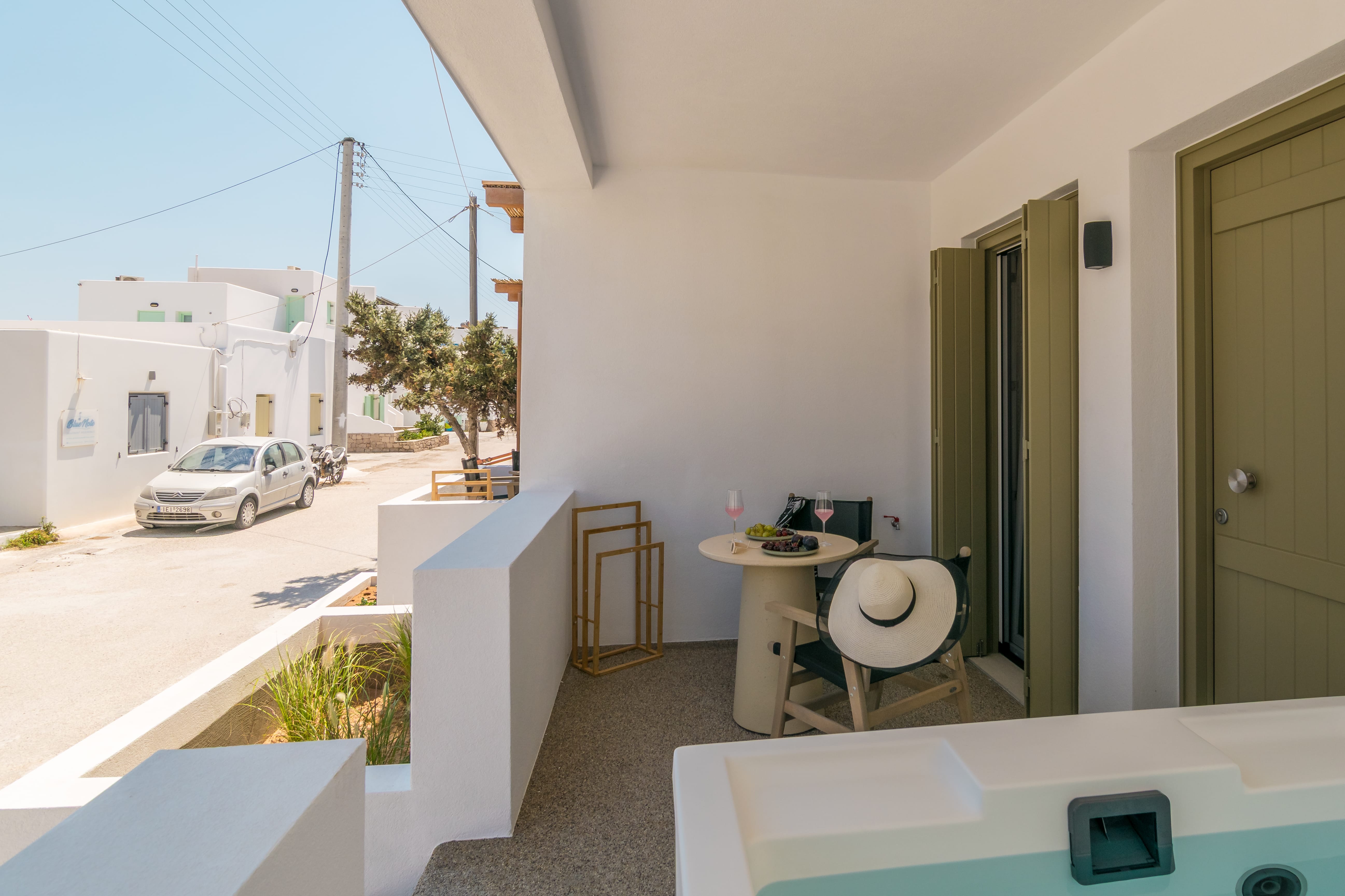 a white balcony with a table and chairs