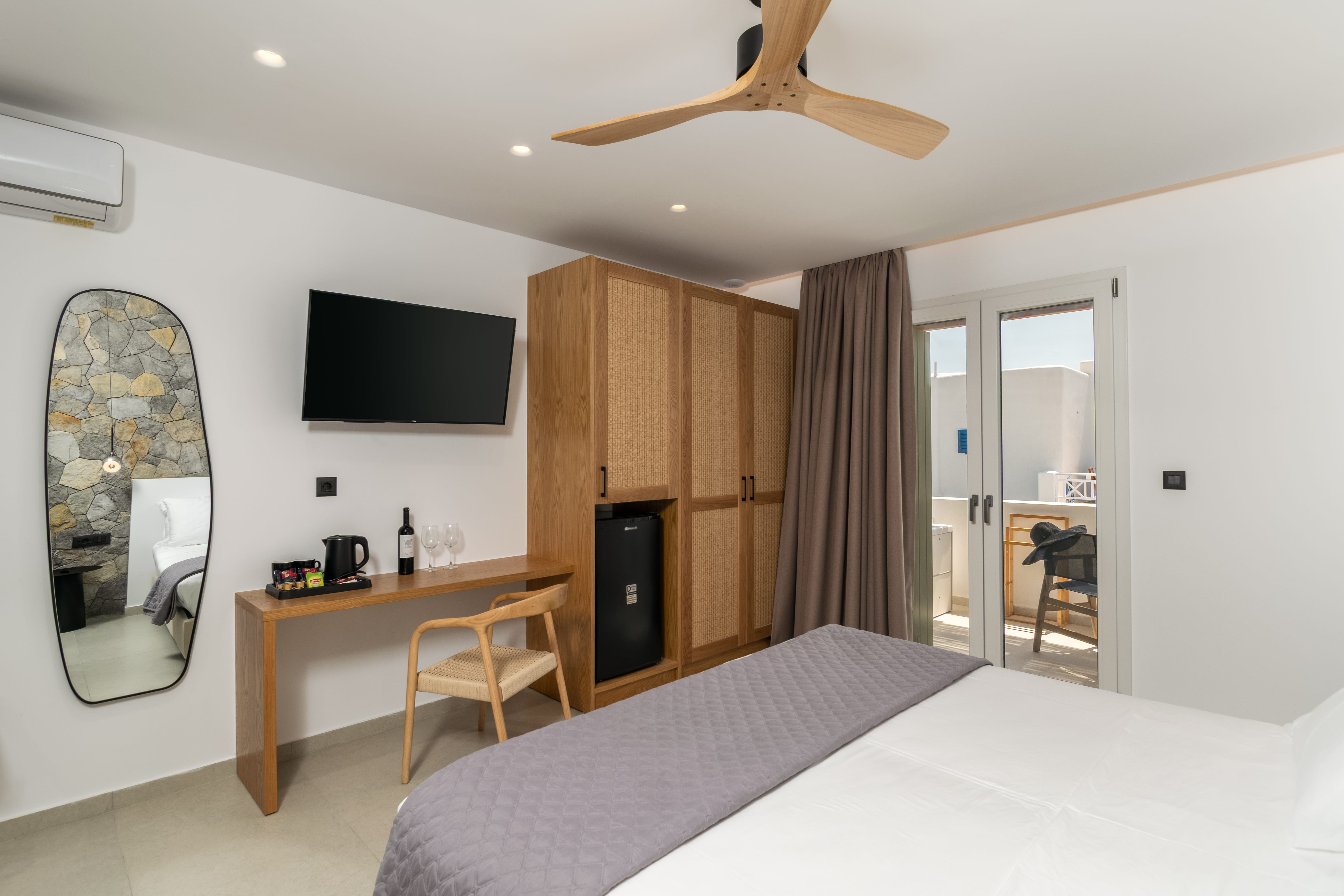 a room with a bed and a desk and a tv